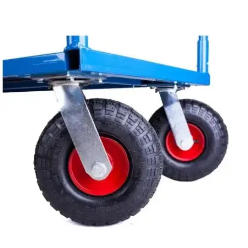 Plattformvogn, nærbilde av to oppblåsbare hjul med sort gummi og rød felg mot blå stålkant.