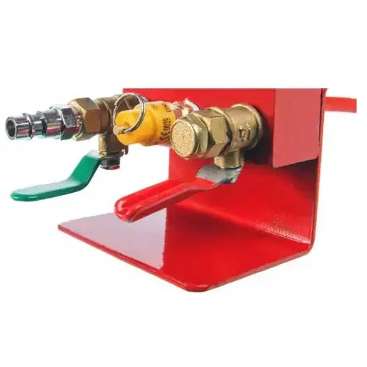 Pneumatisk jekk, detalj av messingventiler med grønne og røde hendler på rød metallbase.