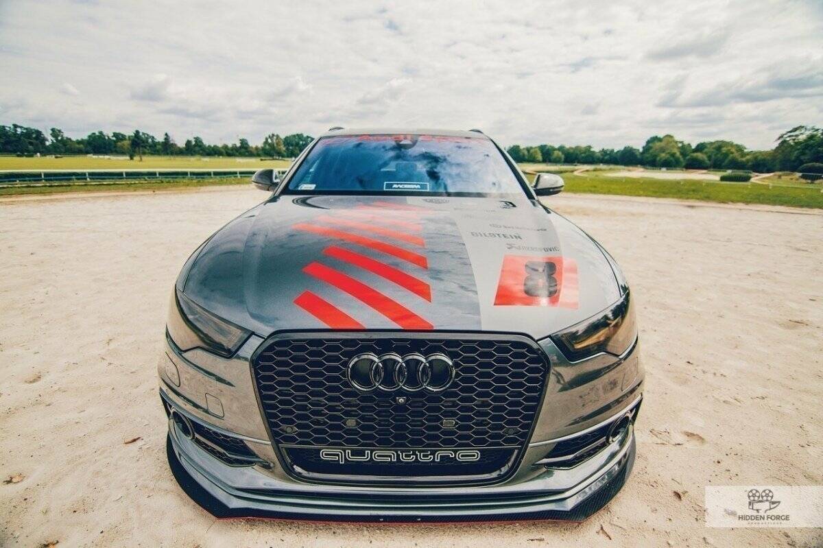 Frontspoiler Audi A6 C7 S-Line sett forfra med sort grill, quattro-logo og røde dekordetaljer.