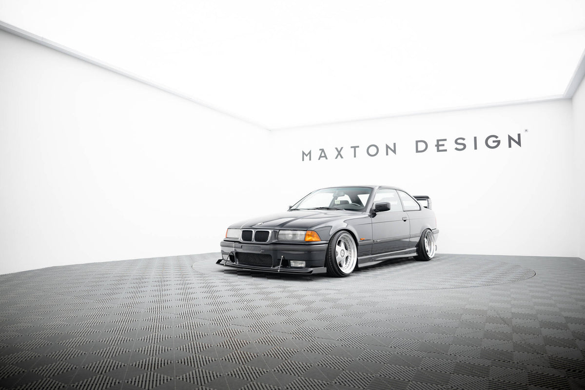 Front splitter på BMW M3 E36 Coupe med brede felger og lav frontspoiler i lyst studio.