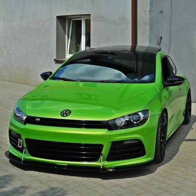 Frontspoiler VW Scirocco R 2009-2013 montert på grønn sportsbil med sort tak, sett forfra på brostein.