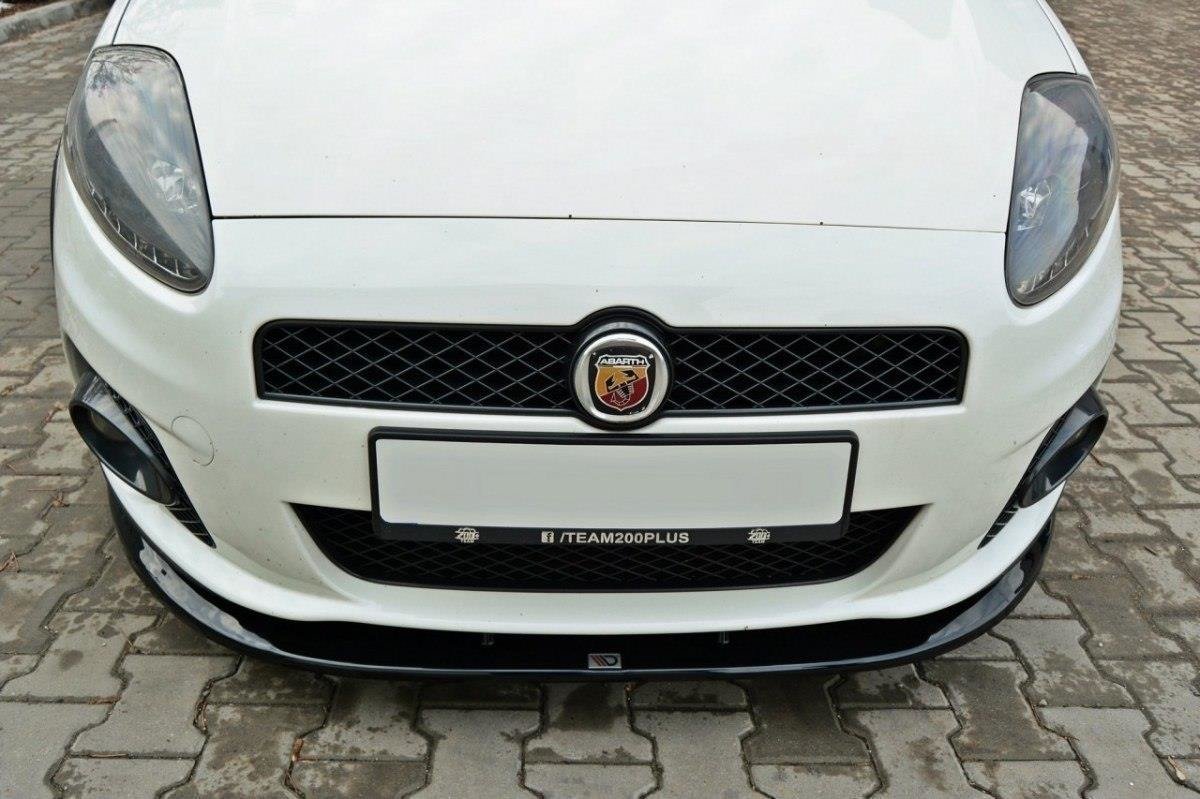 Frontleppe på Fiat Grande Punto Abarth V.2 med sotede frontlykter og svart grill, parkert på brostein.