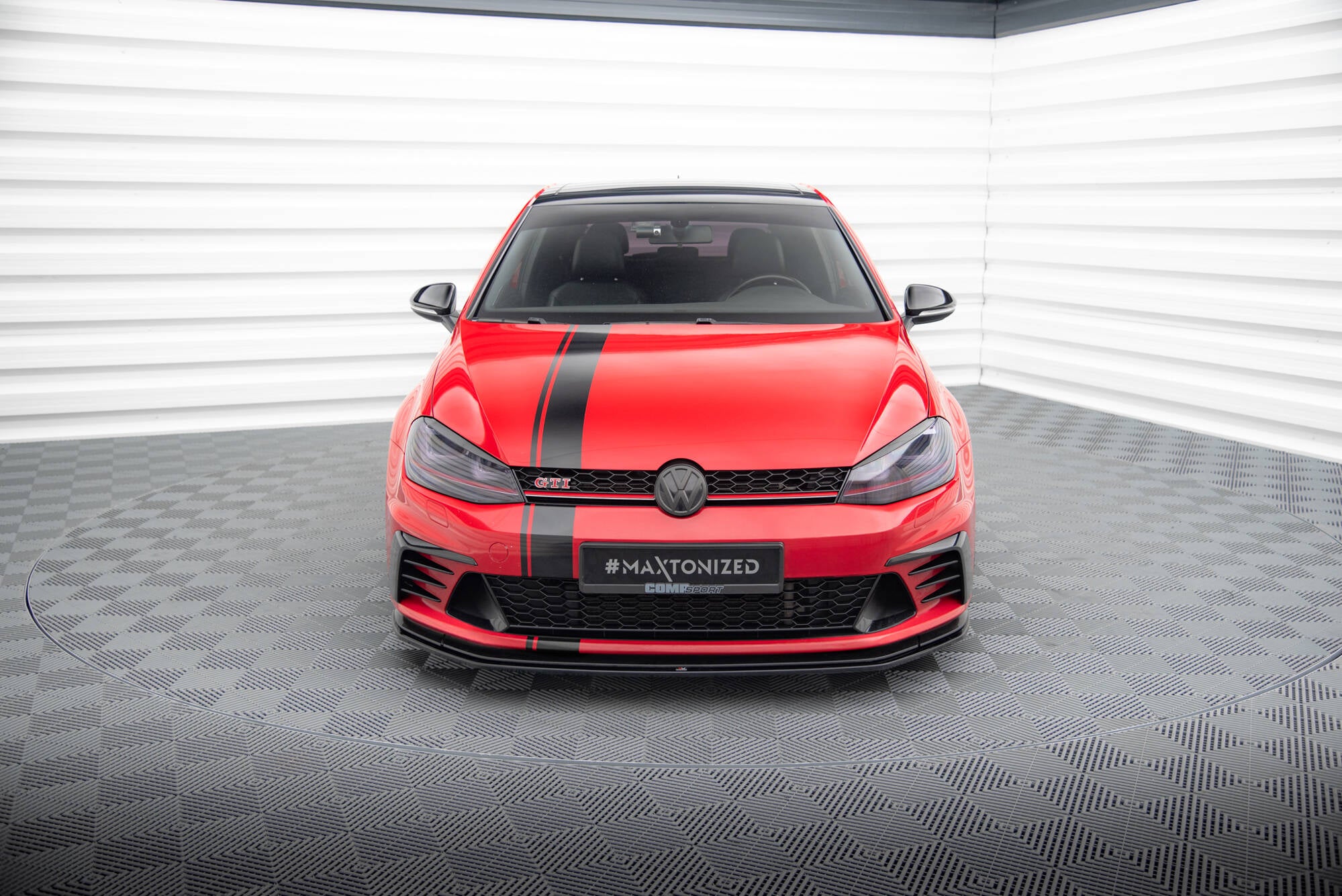 Frontleppe på VW Golf MK7 GTI Clubsport, rød bil med sorte striper og sportslig frontfanger.