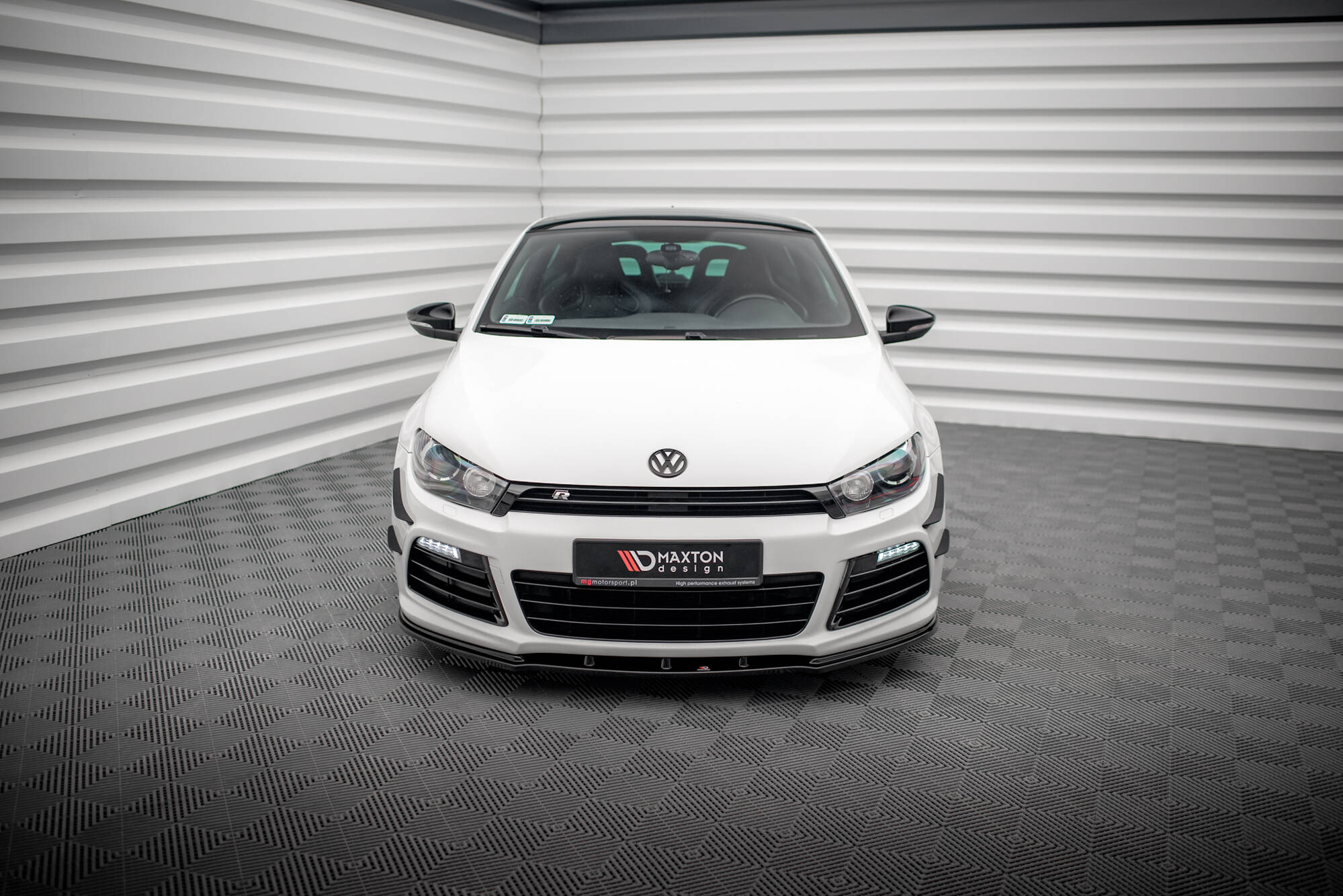 Frontleppe på VW Scirocco R 2008-2014 hvit sportsbil, sorte detaljer, sett forfra i lyst rom.