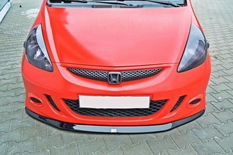 Frontspoiler Honda Jazz MK1 V.1 montert på rød bil med svart panserbeskyttelse og tydelig Honda-emblem.