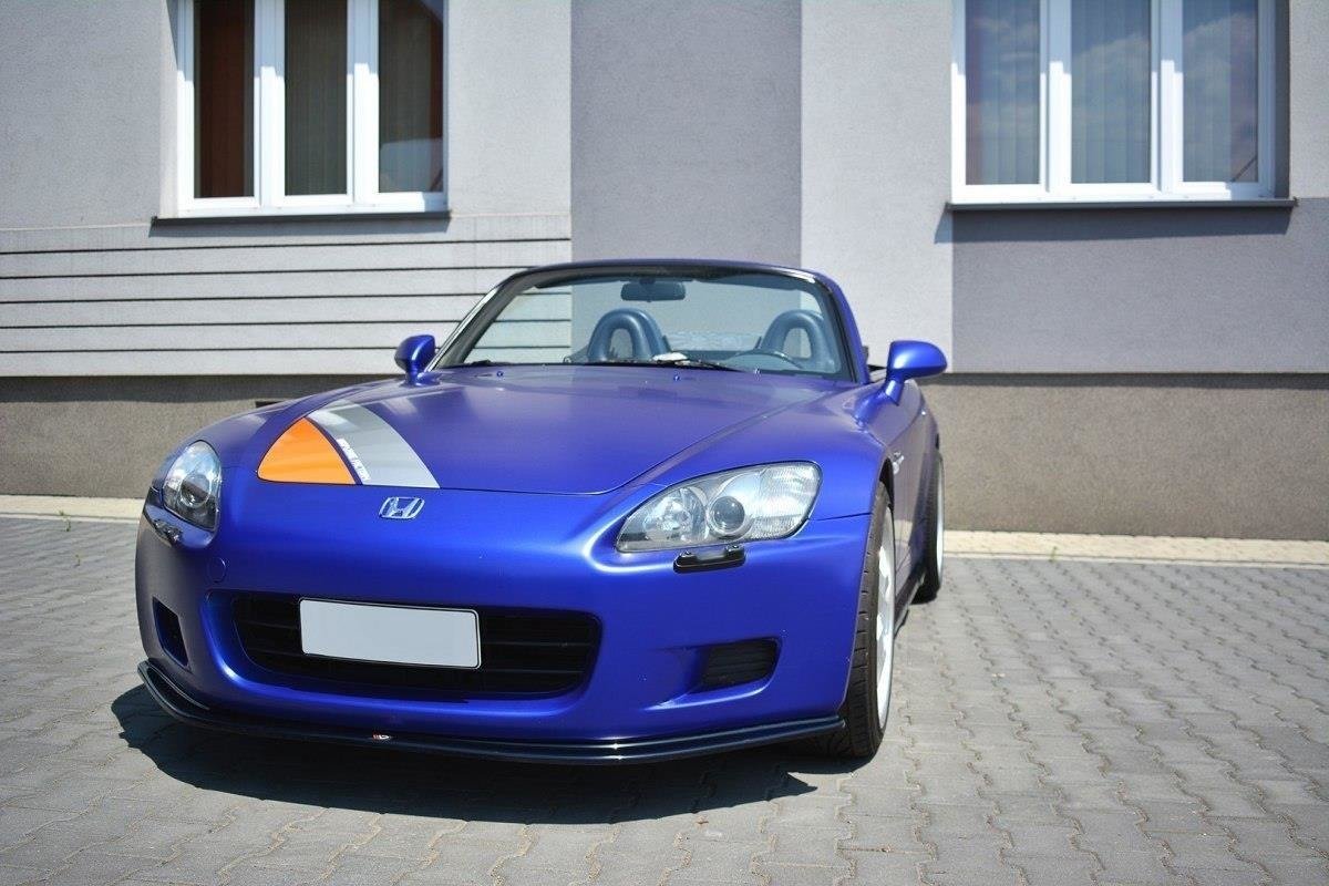 Spoiler på blå Honda S2000 med oransje og grå stripe, parkert rett forfra på brostein.