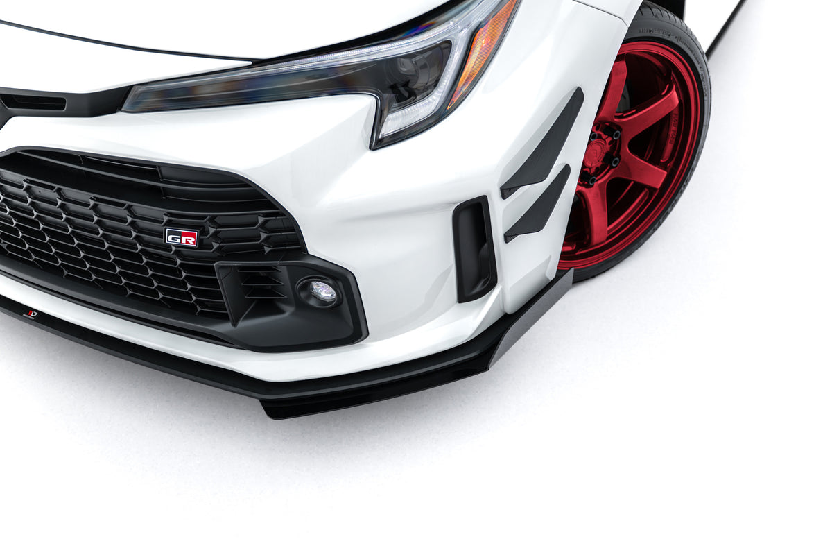Frontfanger canards i blank svart ABS-plast montert på Toyota GR Corolla MK12, sett forfra