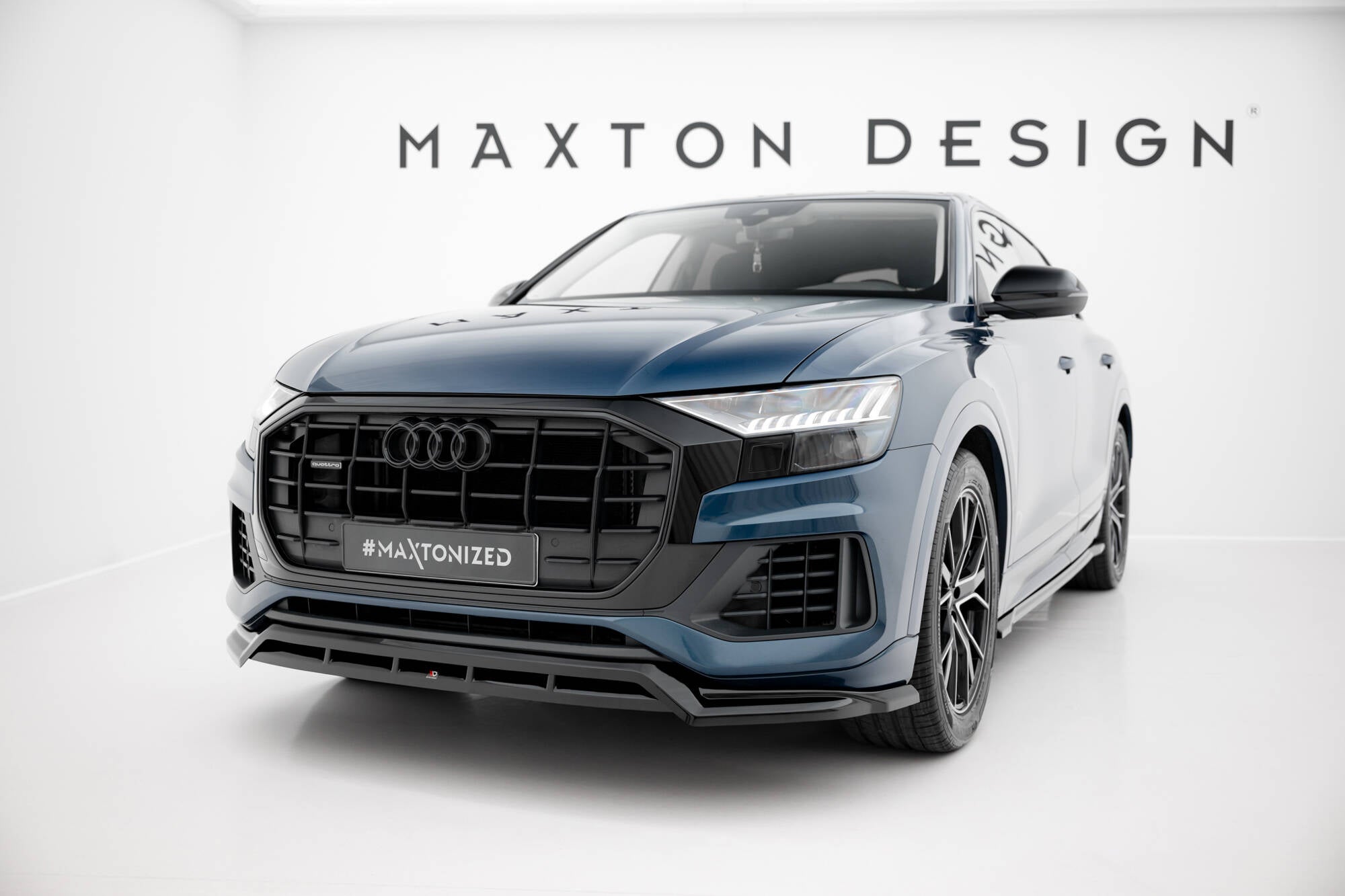 Frontspoiler Audi Q8 MK1 med sorte detaljer sett forfra i lyst studio, Maxton Design-logo bak.