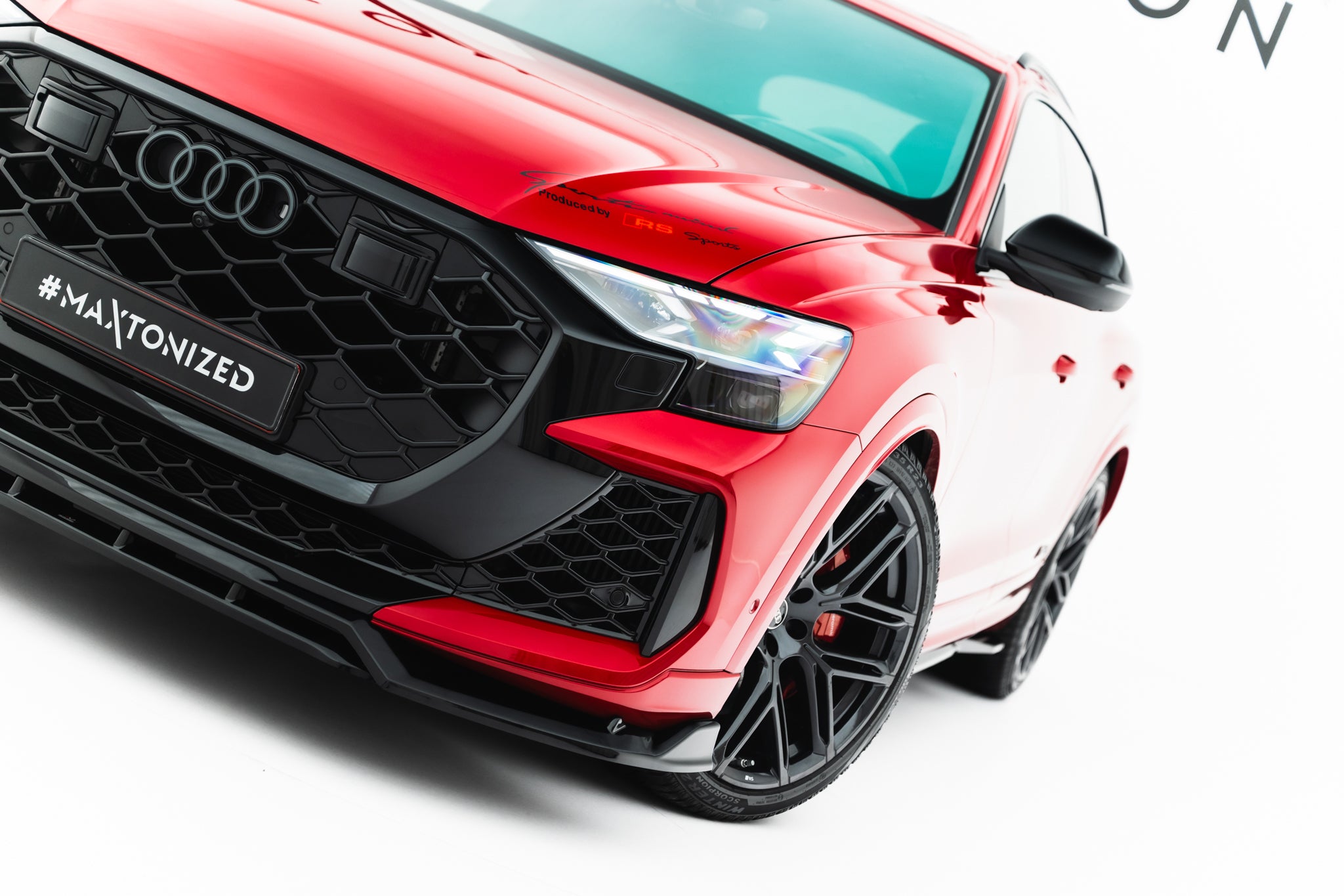Spoiler Audi RSQ8 MK1 Facelift nærbilde med sort grill, høyre frontlykt og store svarte felger.