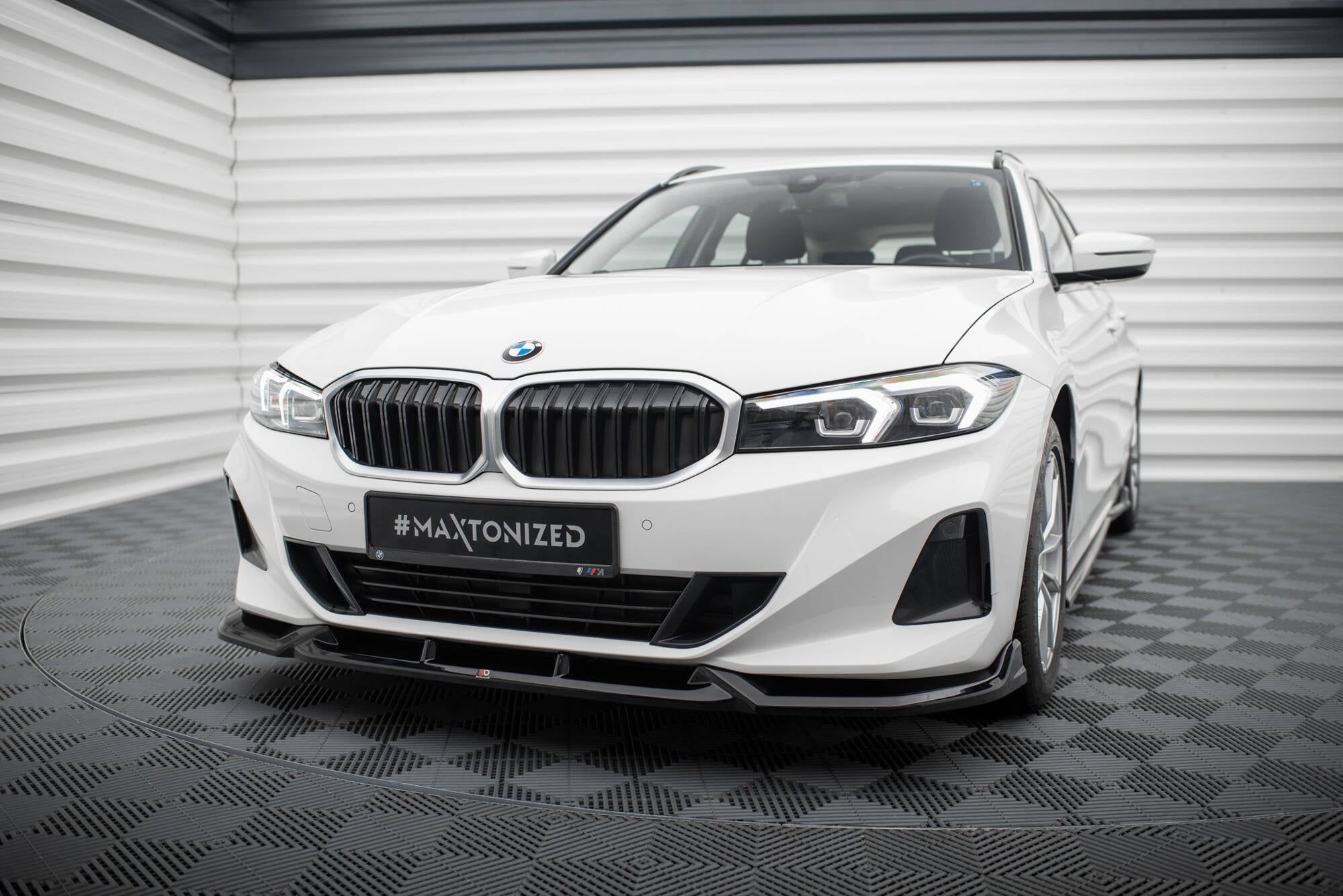 Frontspoiler til BMW 3 Sedan G20 facelift, sort plast montert foran på hvit bil med LED-lykter.