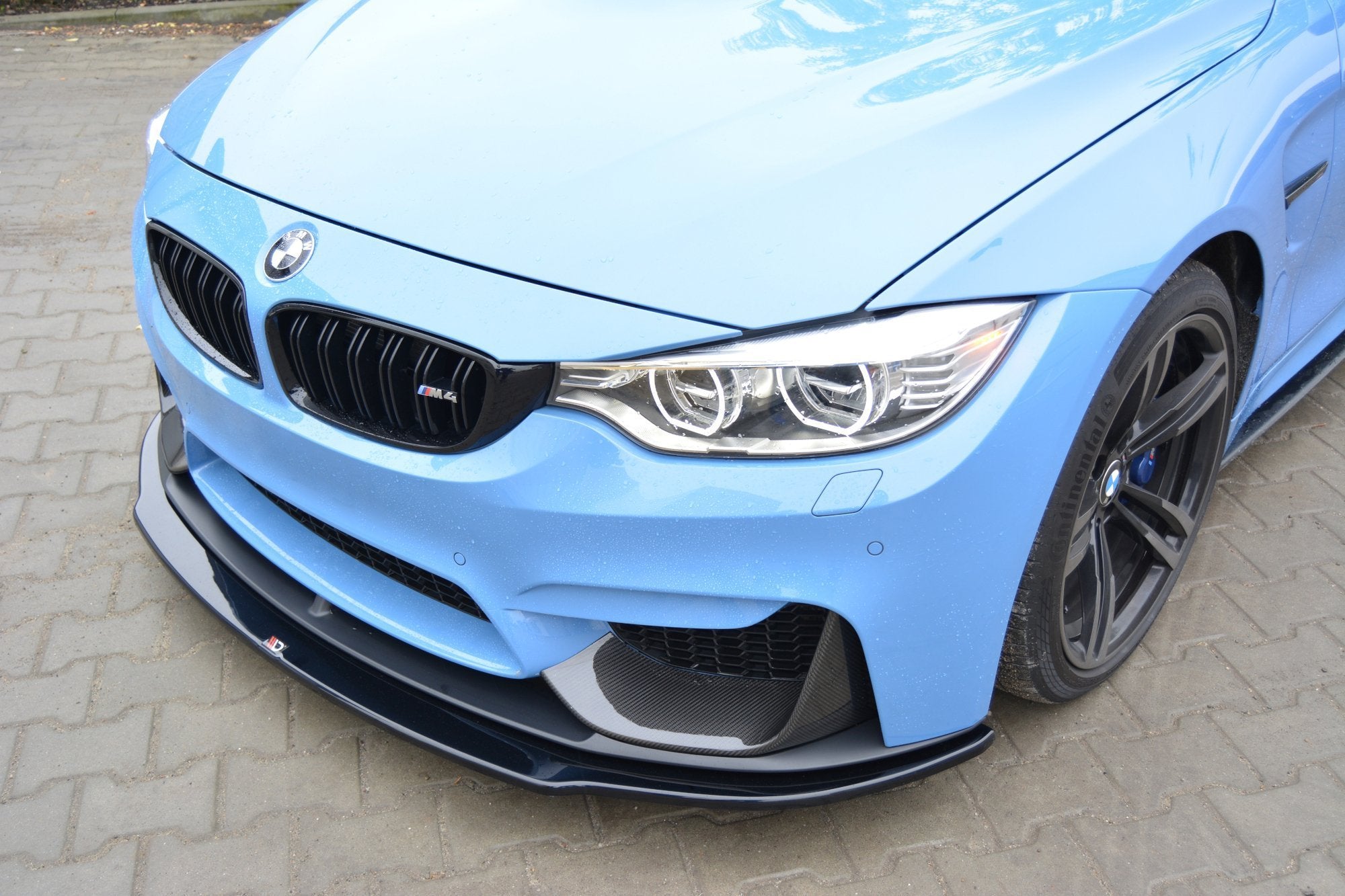 Frontleppe på BMW M4 F82 M-Performance med karbonfiber splitter, sorte detaljer og synlige LED-frontlykter.