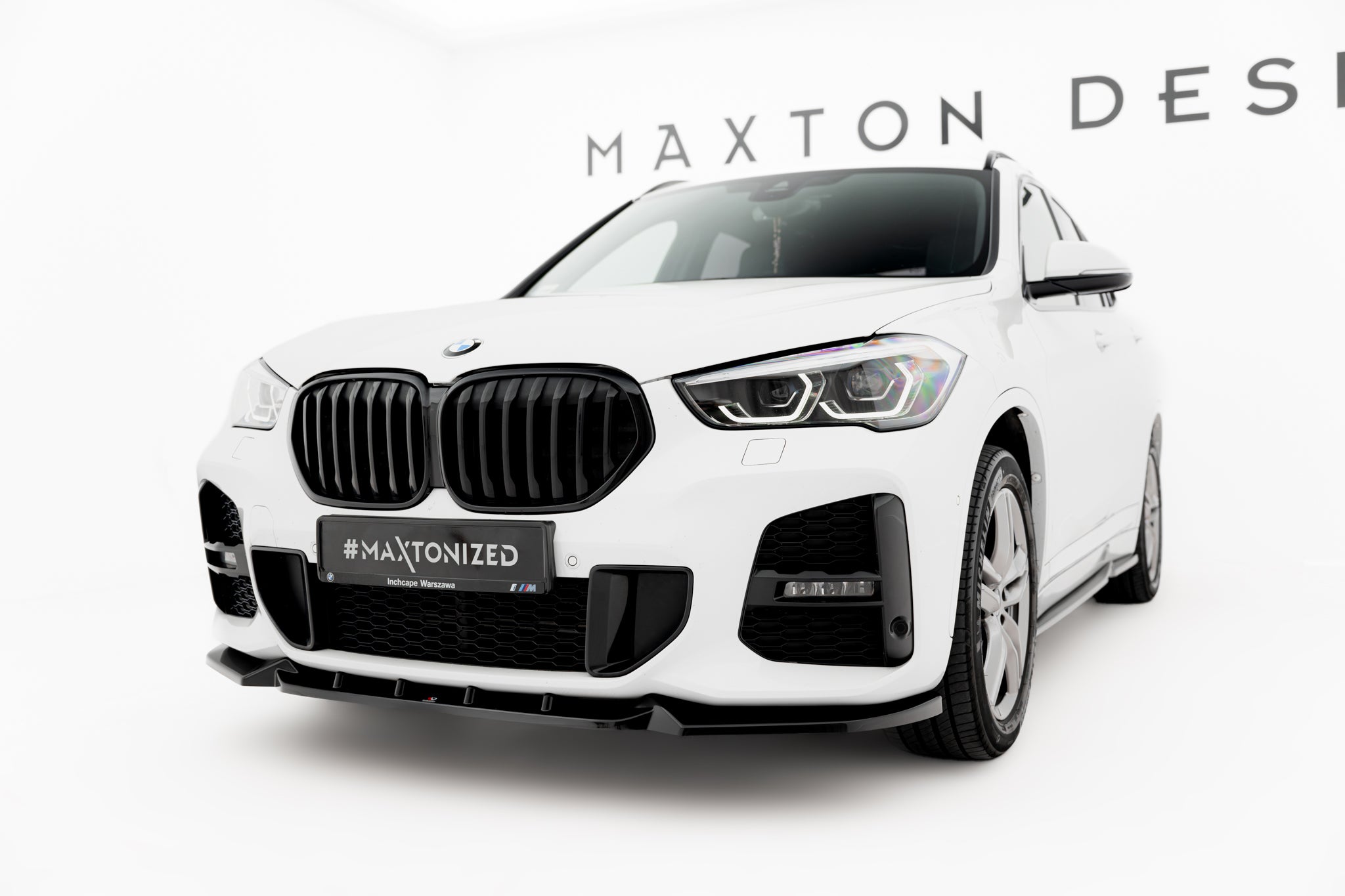Frontspoiler BMW X1 M-Pakke F48 Facelift med sorte detaljer, sett forfra i halvt skrå vinkel.
