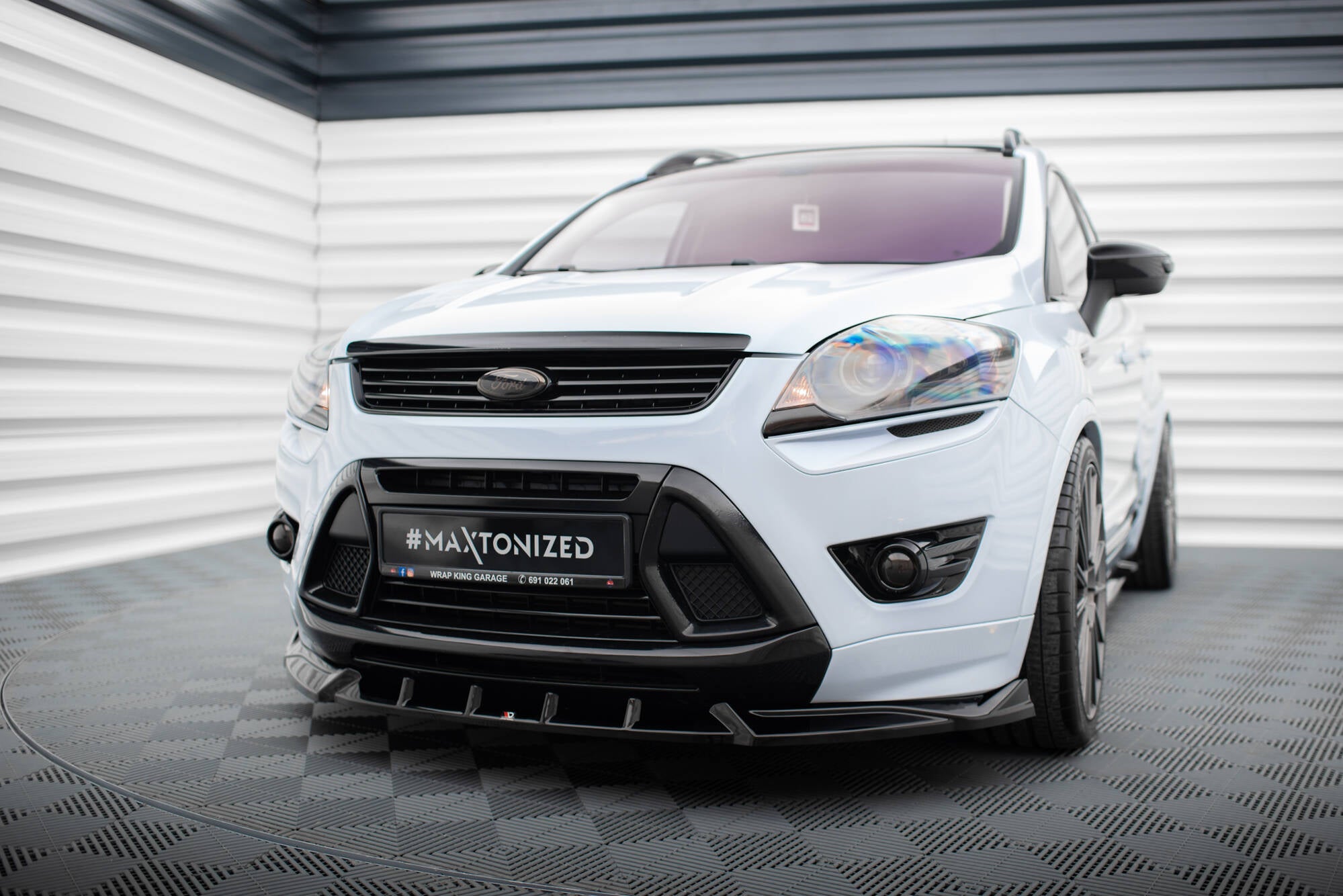 Frontspoiler Ford Kuga St MK1 på hvit bil sett forfra med svarte detaljer og sportslige felger.