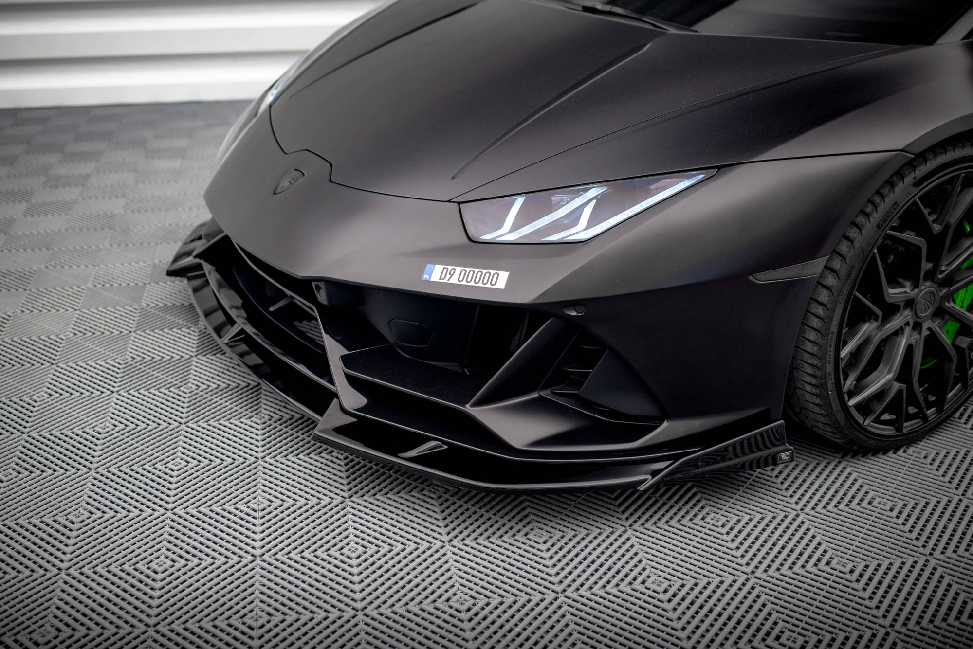 Front splitter Lamborghini Huracan Evo AWD med matt sort lakk, LED-frontlykter og grønne bremsecalipere.