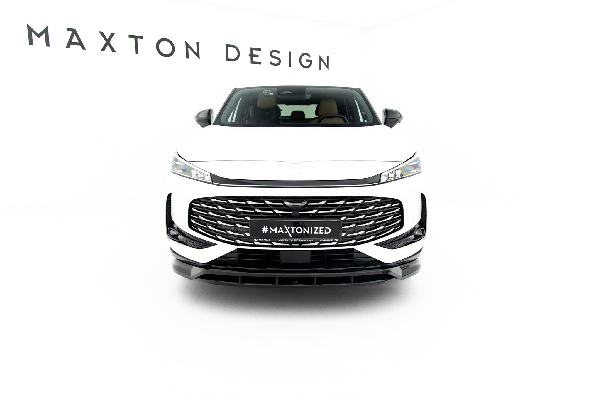 Frontleppe på MG Hs MK2 med svart og sølv grill, brune seter og hvit bil mot studiohvit bakgrunn.