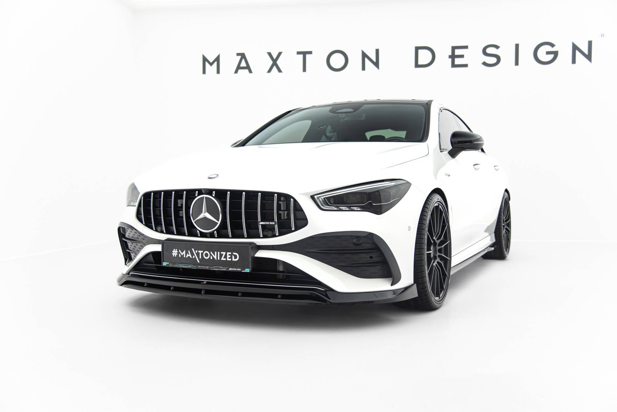 Frontspoiler Mercedes CLA 35 Coupe på hvit sportsbil med sort grill og svarte felger i lyst studio.
