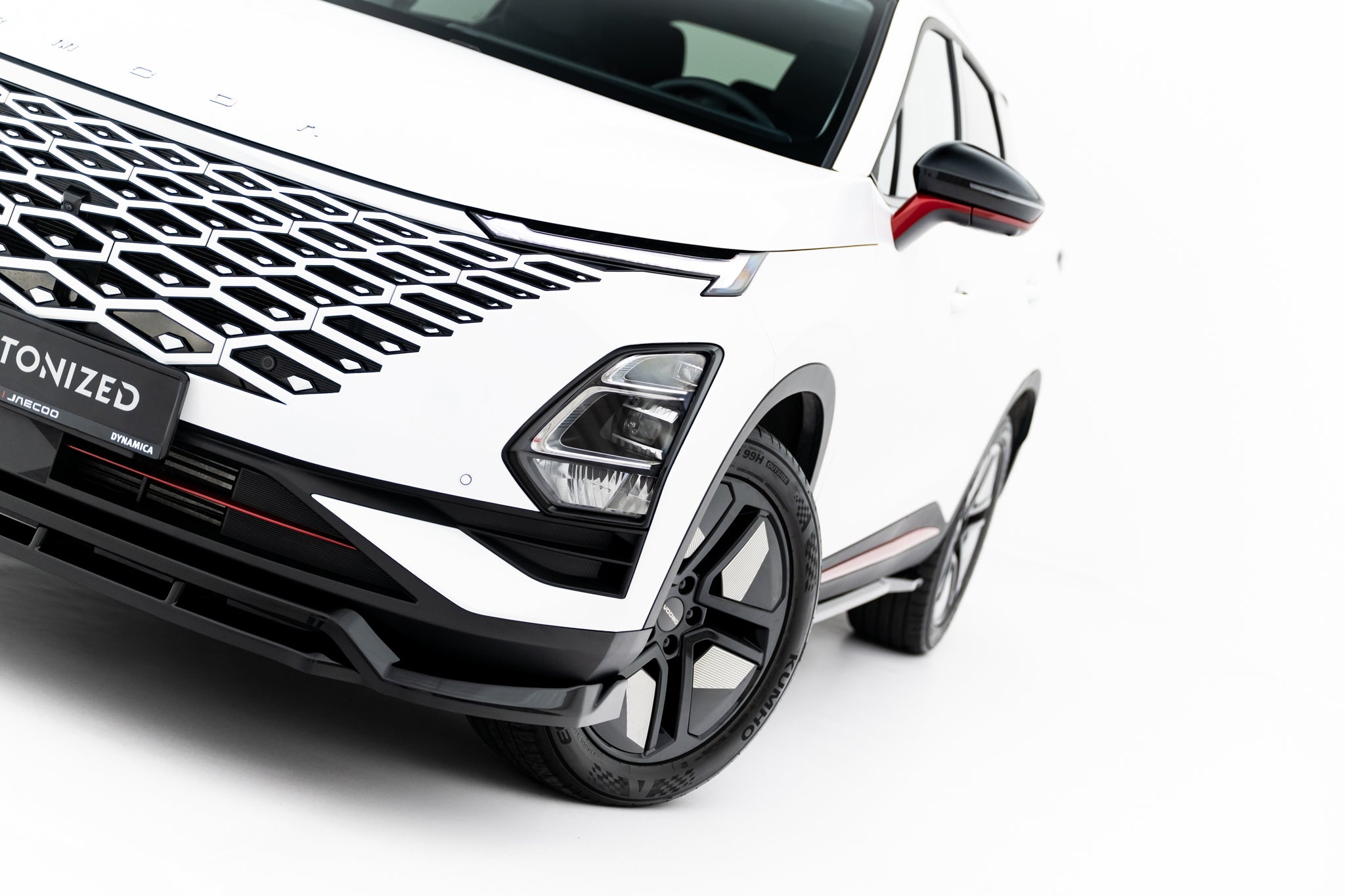 Frontleppe på Omoda 5 MK1 med svart grill, røde detaljer og synlige aluminiumsfelger.