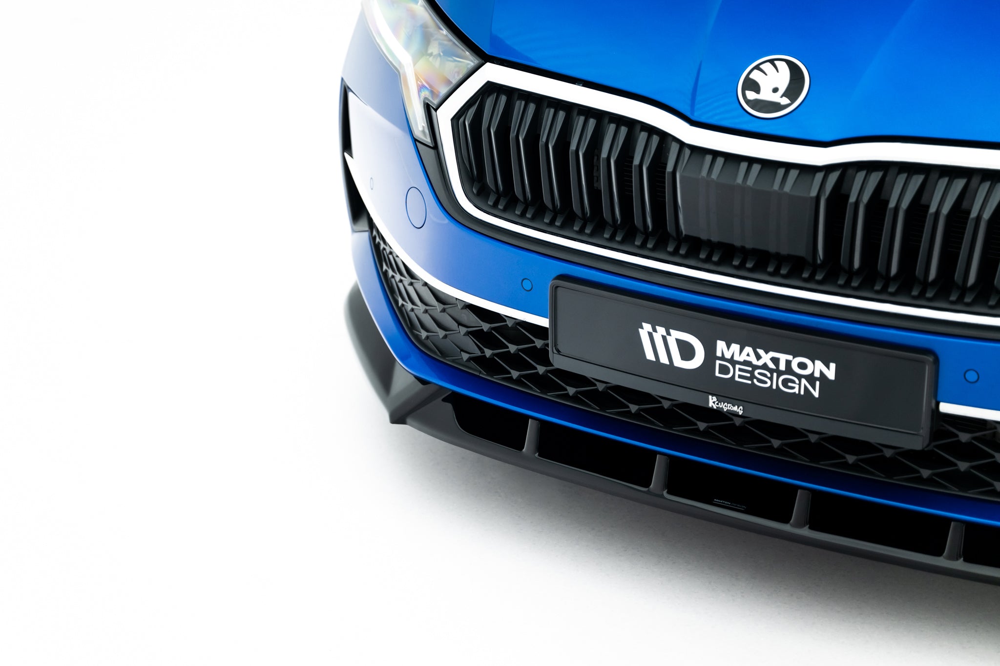 Spoiler på Skoda Octavia MK4 Facelift, nærbilde av sort frontspoiler og grill med Maxton Design-logo.