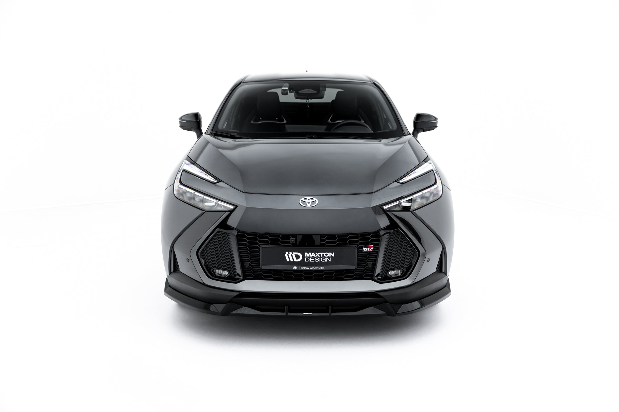 Spoiler på Toyota C-Hr MK2 sett forfra med sorte detaljer, LED-lys og Maxton Design-skilt.