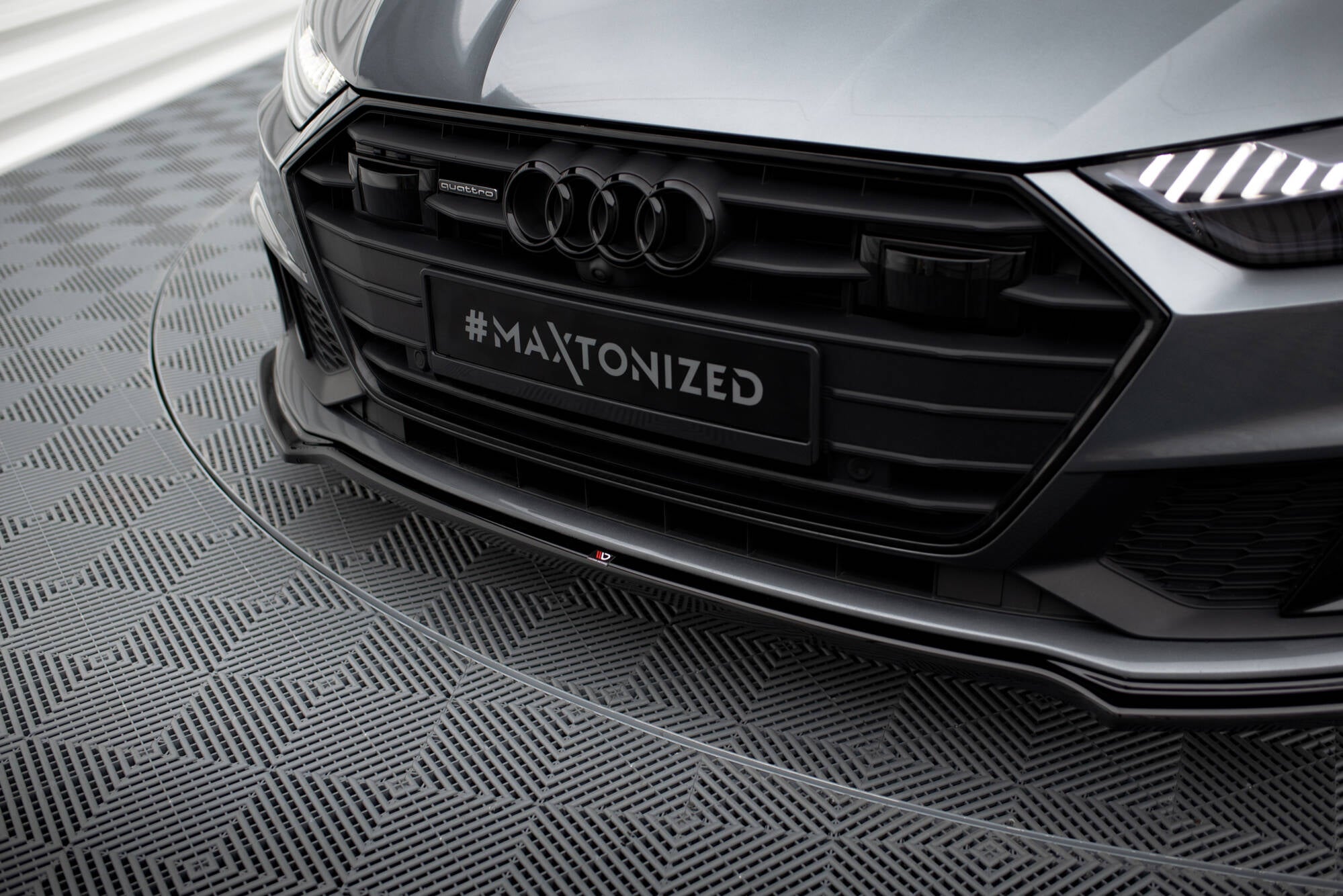 Spoiler til Audi A7 S-Line C8 vist som nærbilde av front med svart grill og blanke detaljer.