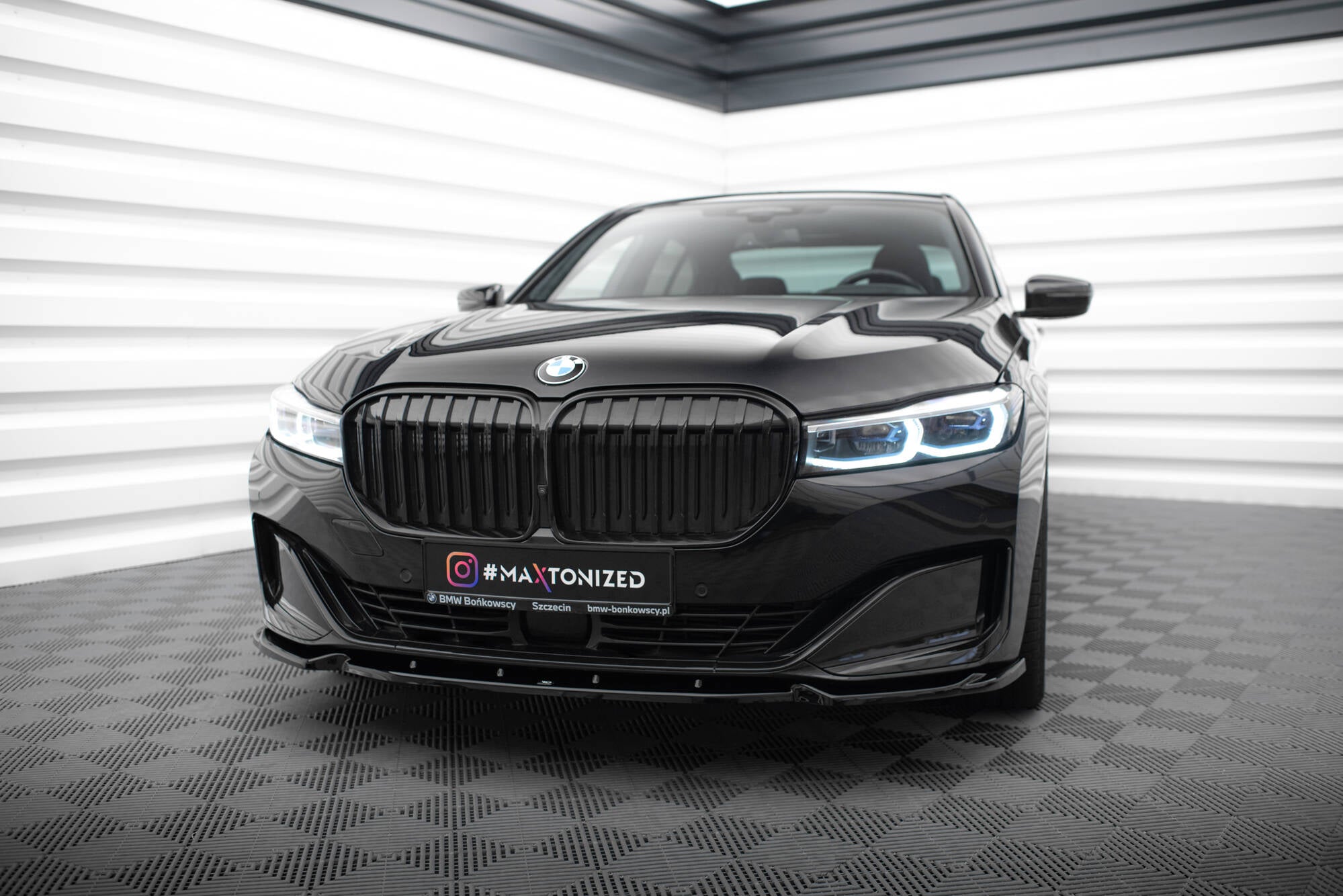 Frontspoiler BMW 7 G11/G12 Facelift V.1 montert på svart bil med nyregrill og LED-frontlykter.