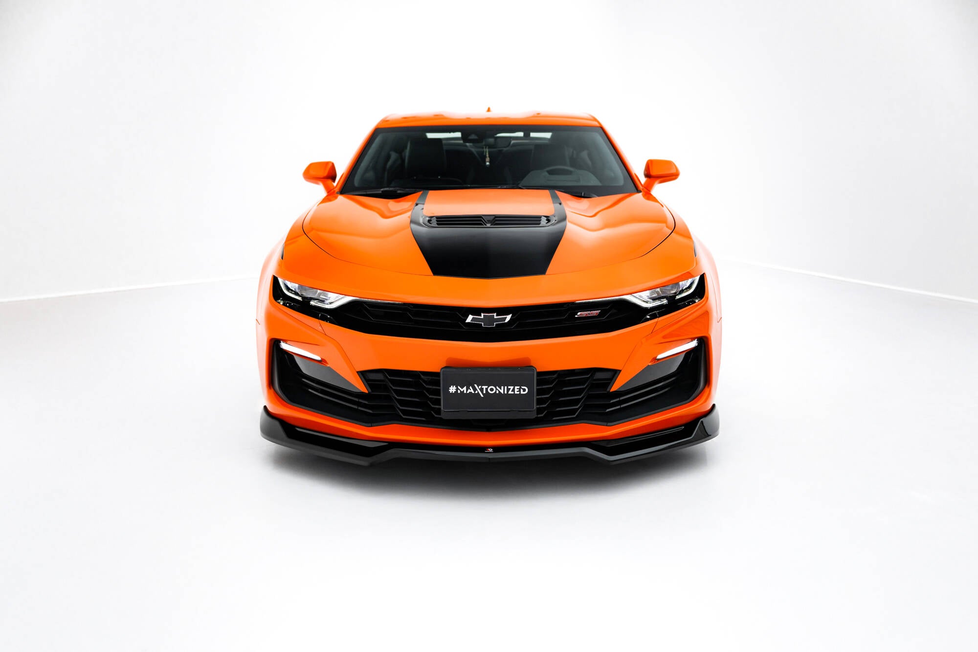 Frontleppe på oransje Chevrolet Camaro SS MK6 Facelift med svart hette og brede sorte detaljer foran.
