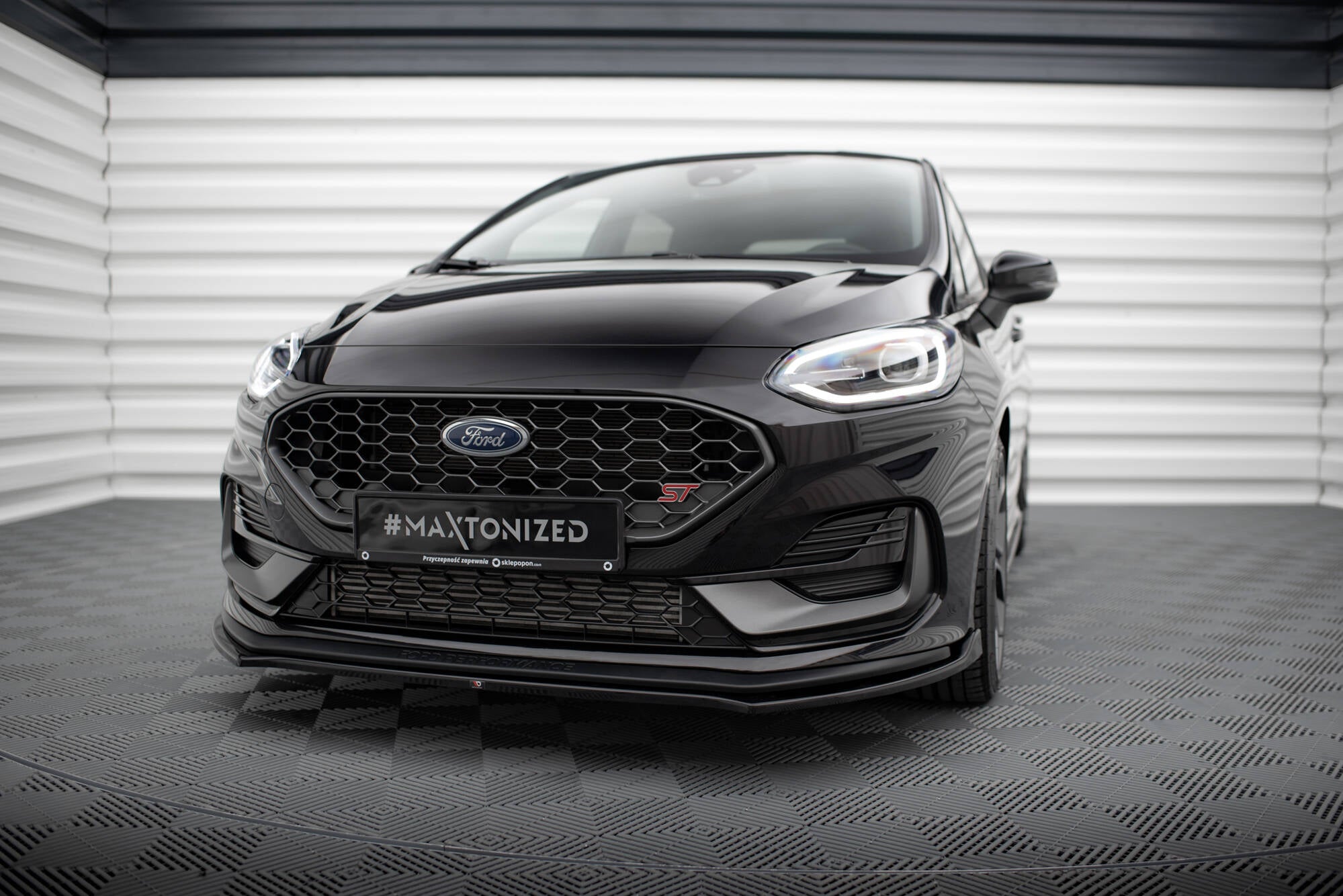 Frontspoiler til Ford Fiesta MK8 Facelift med sportslig sort frontfanger og LED-lys sett forfra.