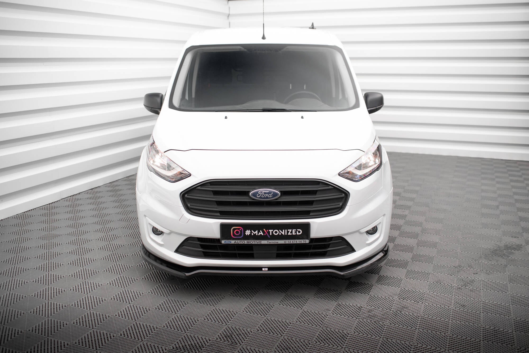 Frontleppe på Ford Transit Connect MK2 Facelift sett forfra med sort grill og hvite sidespeil.
