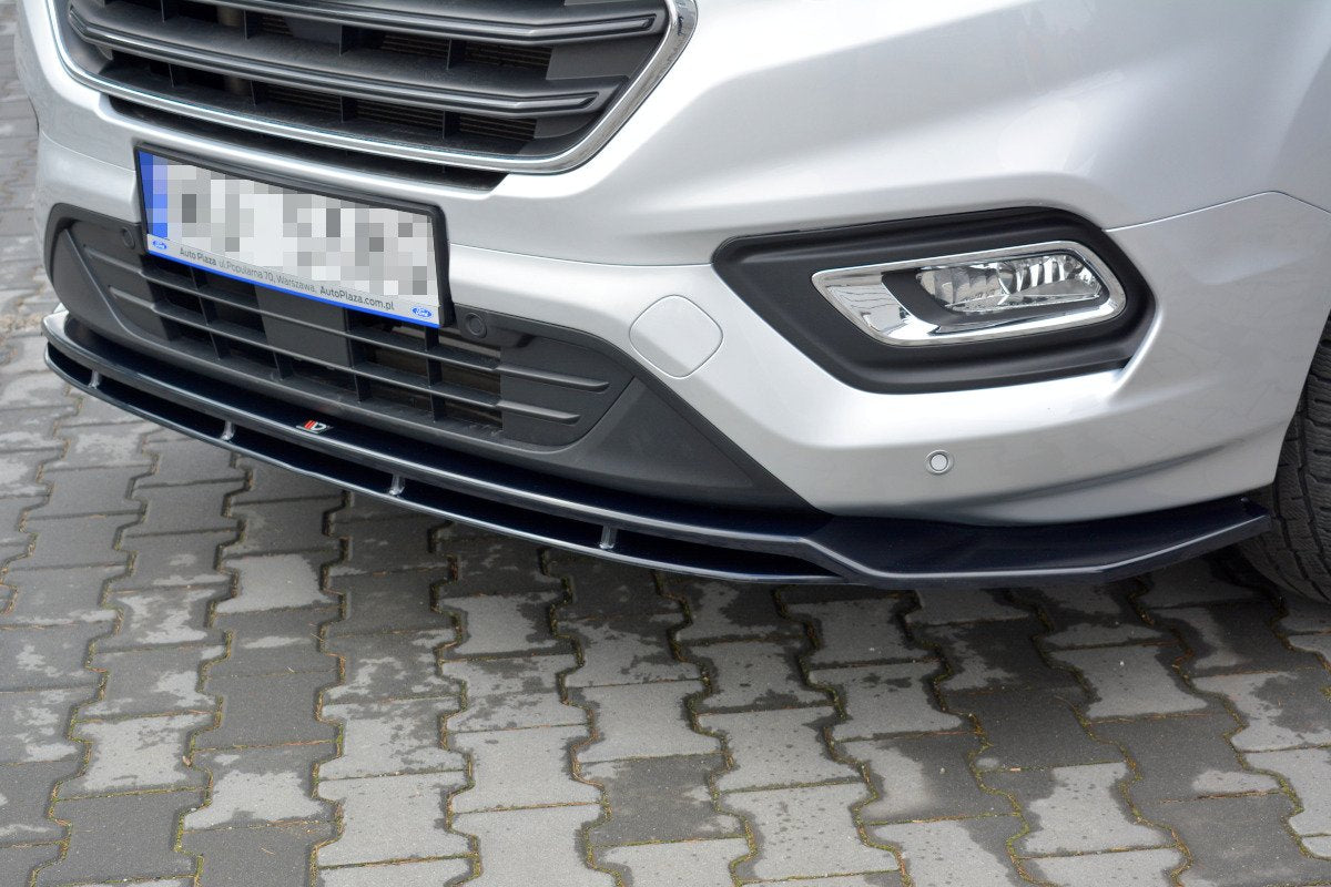 Frontleppe til Ford Transit Custom MK1 Facelift, sort plast splitter montert under frontfanger, sett skrått forfra.