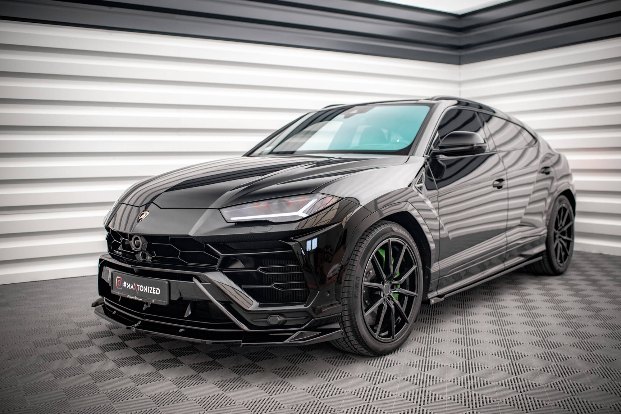 Frontspoiler Lamborghini Urus MK1 V.1 på sort SUV med matt svarte felger og grønne bremsekalipere.