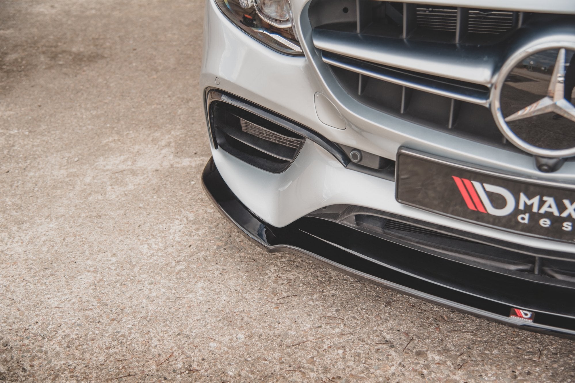 Front splitter på Mercedes E63 AMG med sort spoiler under støtfangeren, nærbilde av høyre side.