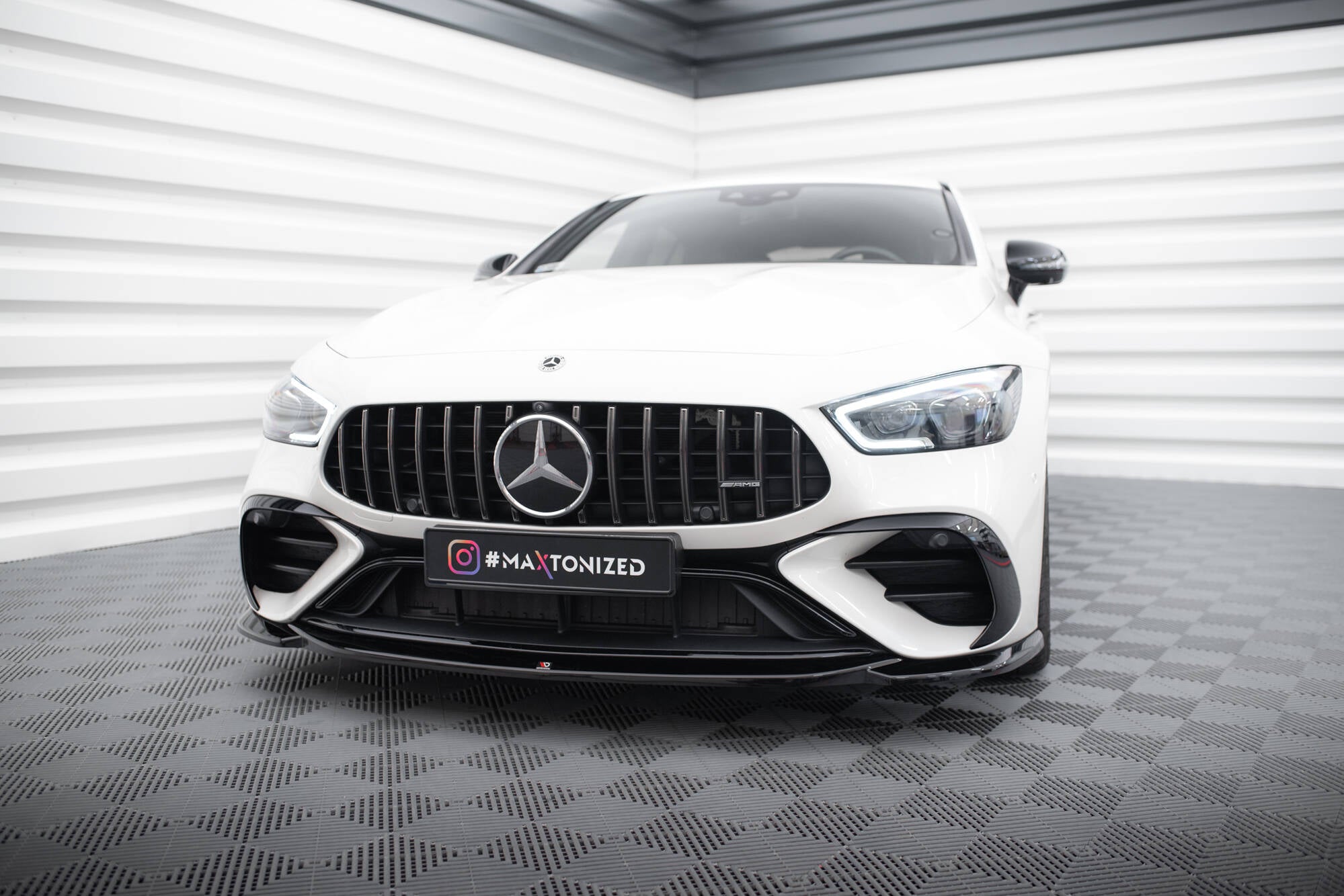 Frontspoiler Mercedes GT 43 4 Dør Coupe med sort grill og store luftinntak sett forfra.