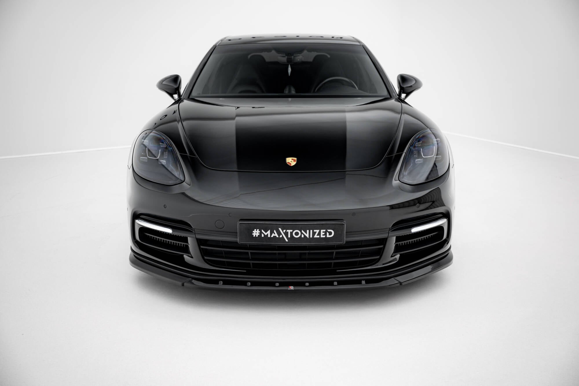 Frontleppe på Porsche Panamera E-Hybrid 971, sort bil forfra med emblem og sporty frontfanger.