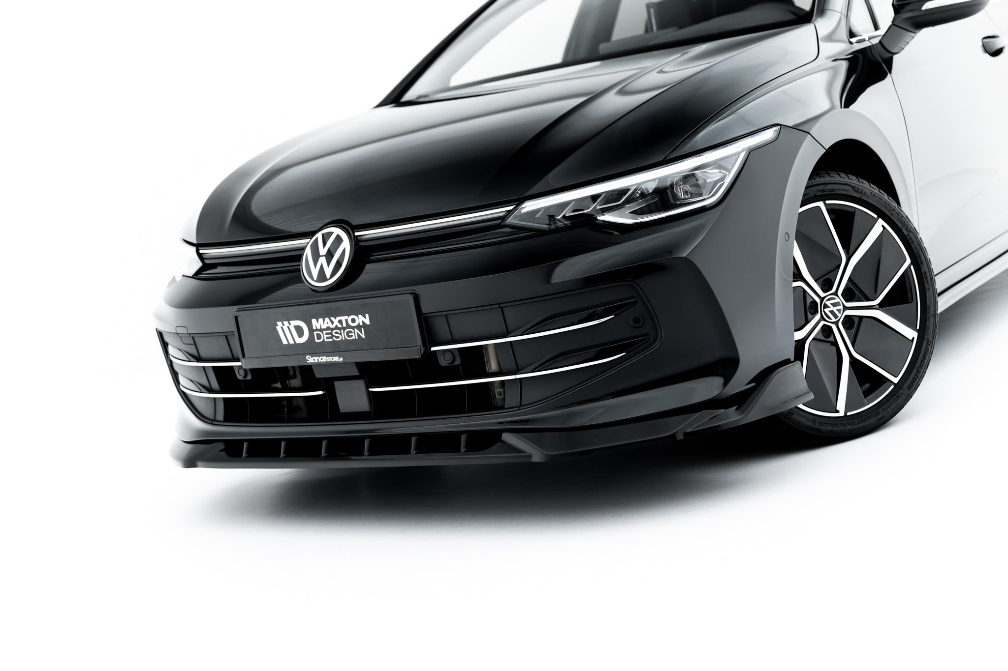 Frontleppe VW Golf MK8 Facelift V.1 på sort bil med kromgrill og sportsfelg, sett skrått forfra.