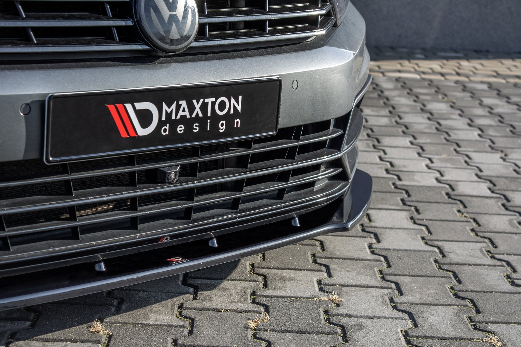 Front splitter på VW Passat R-Line B8 med sort dekorlist, Maxton Design-logo og detaljer i grill og støtfanger.