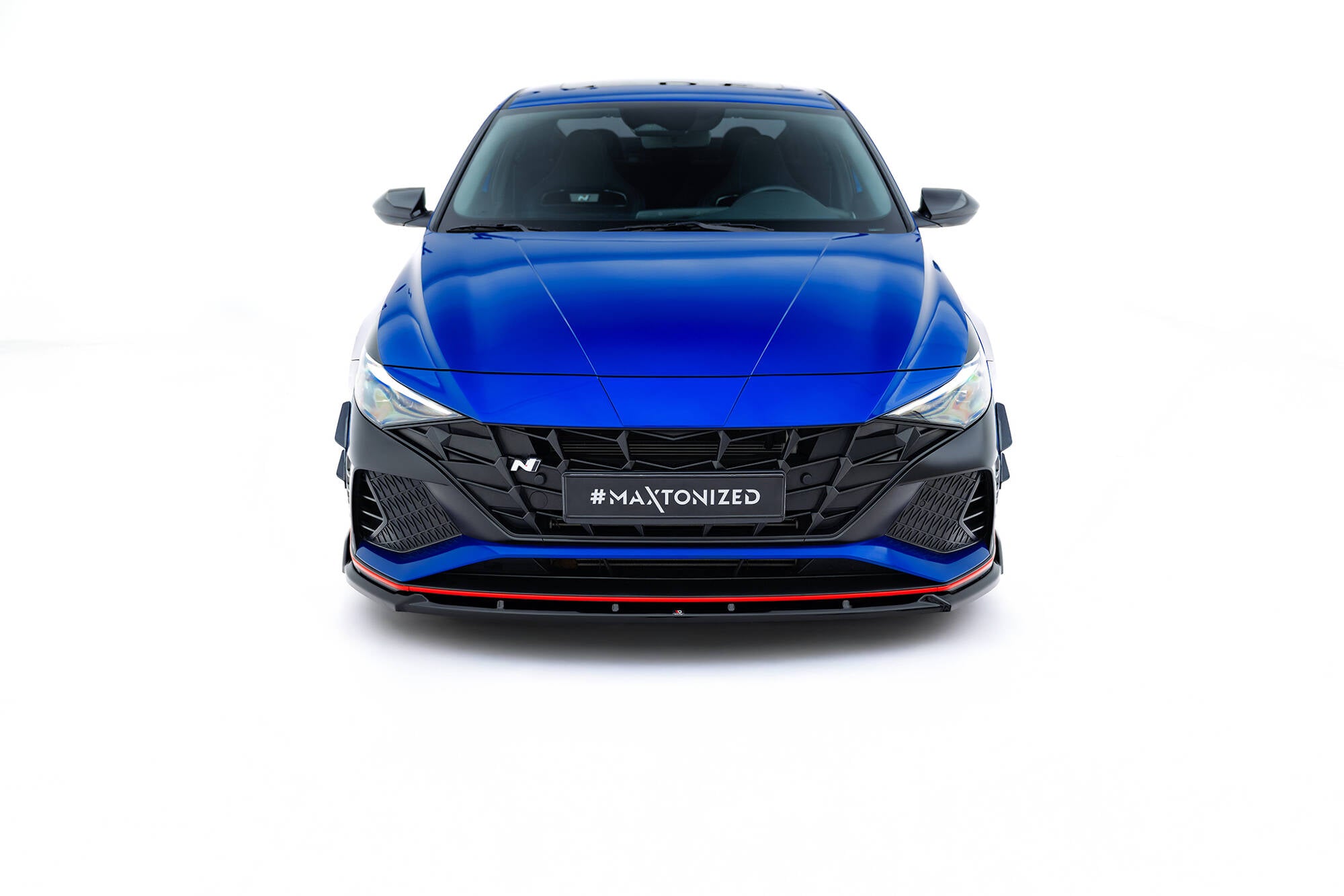 Frontleppe på Hyundai Elantra N MK7 V.2 med sort grill og rød stripe, sett forfra mot hvit bakgrunn.