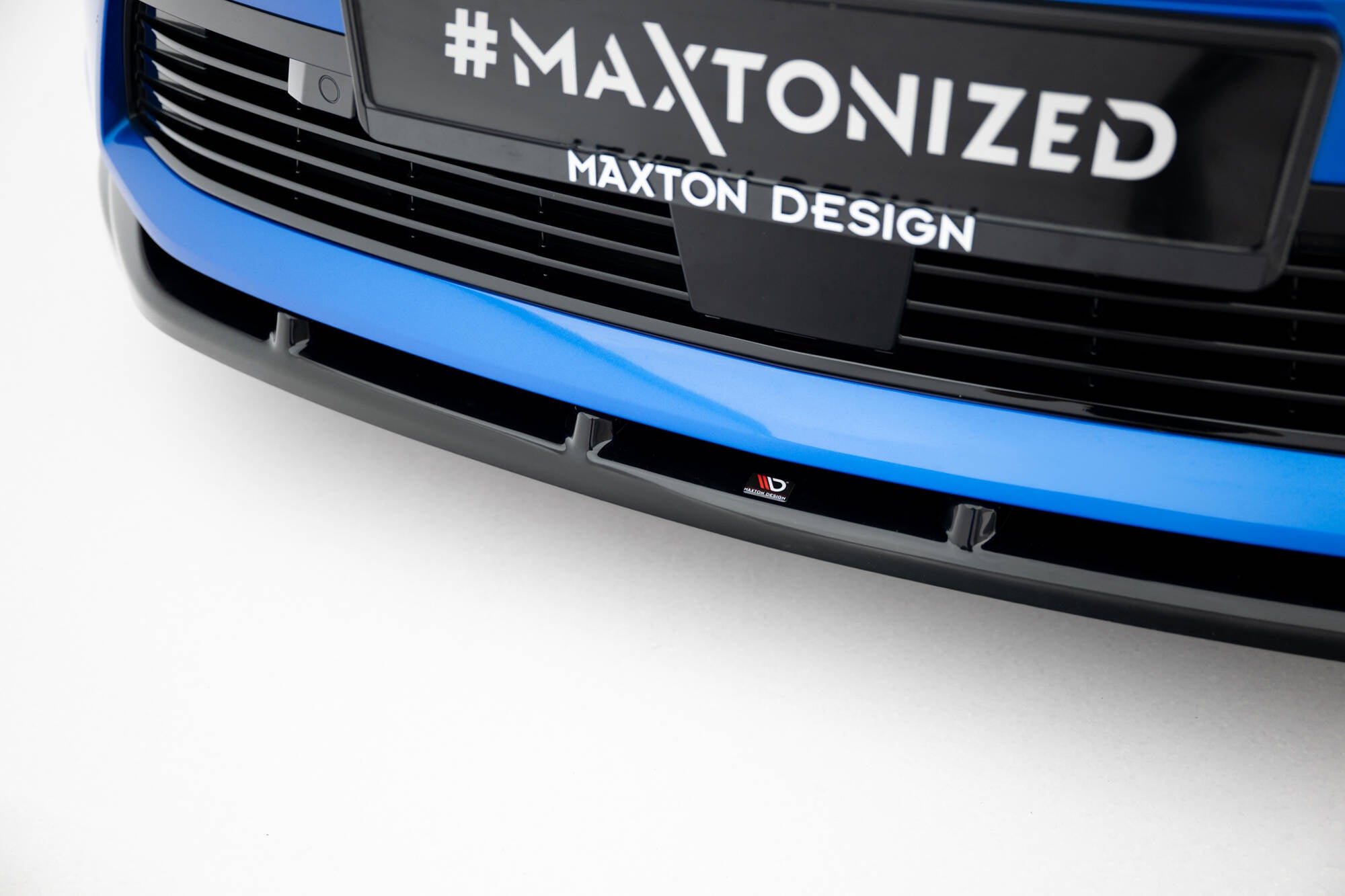 Spoiler til Opel Astra L V.2 i blå og sort med Maxton Design-logo sett rett forfra.