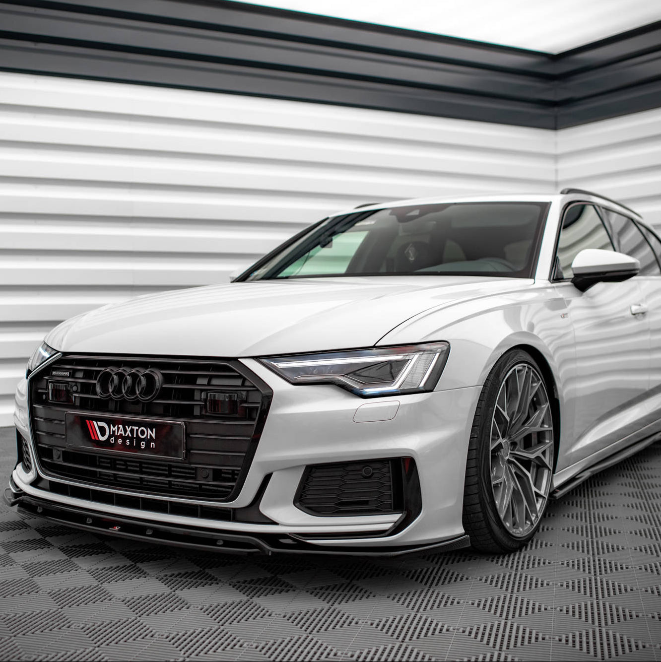 Frontspoiler Audi A6 S-Line C8 montert på hvit stasjonsvogn med sorte detaljer og alufelger.