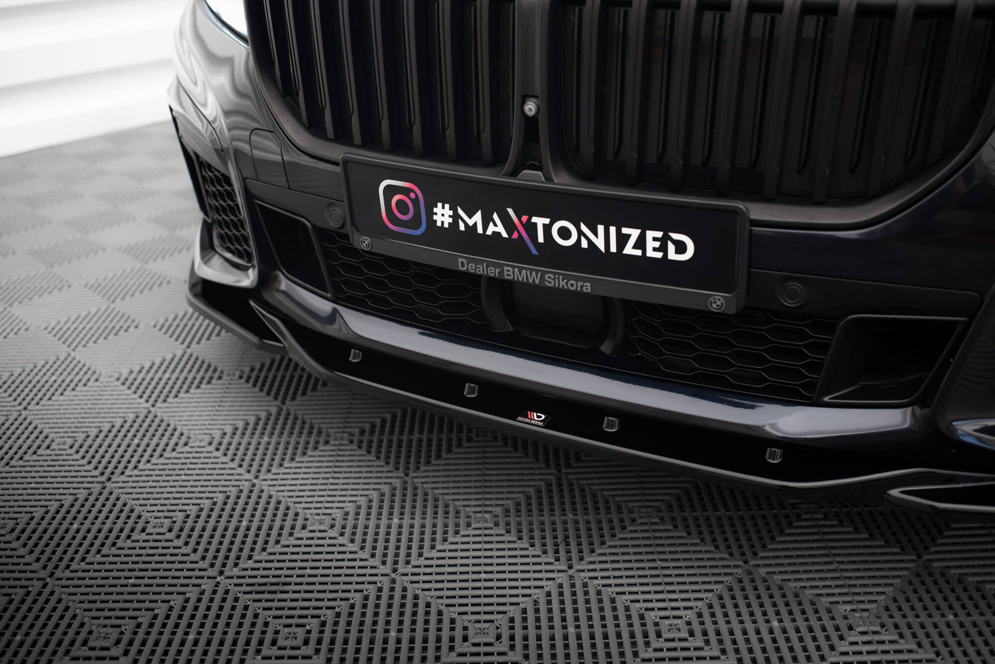 Spoiler til BMW 7 M-Pakke G11/G12 Facelift V.3 i sort glans, montert foran på sort bil.
