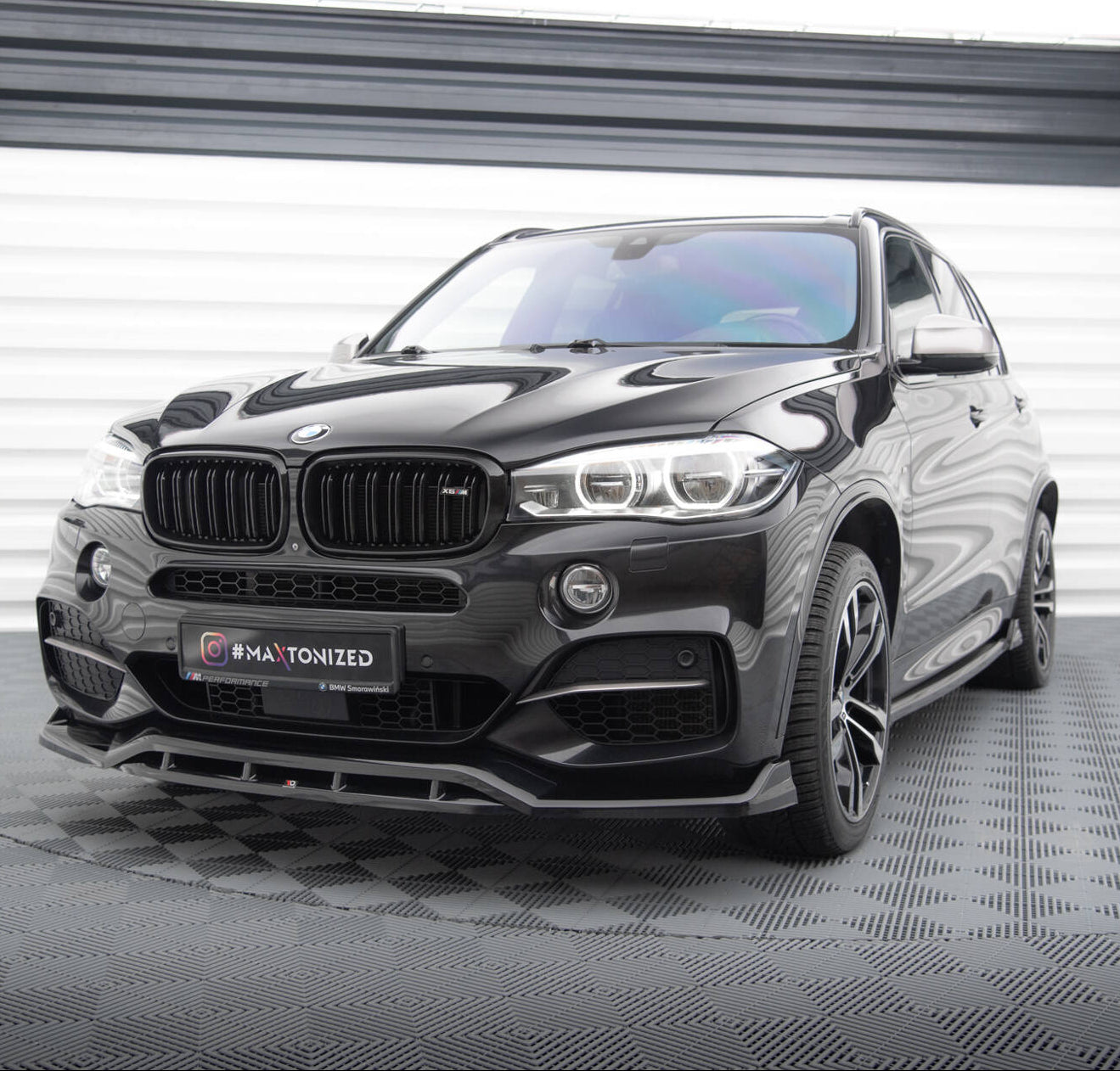 Frontspoiler BMW X5 F15 M-Pakke V.3 på sort SUV med LED-frontlykter og store felger i lyst studio.