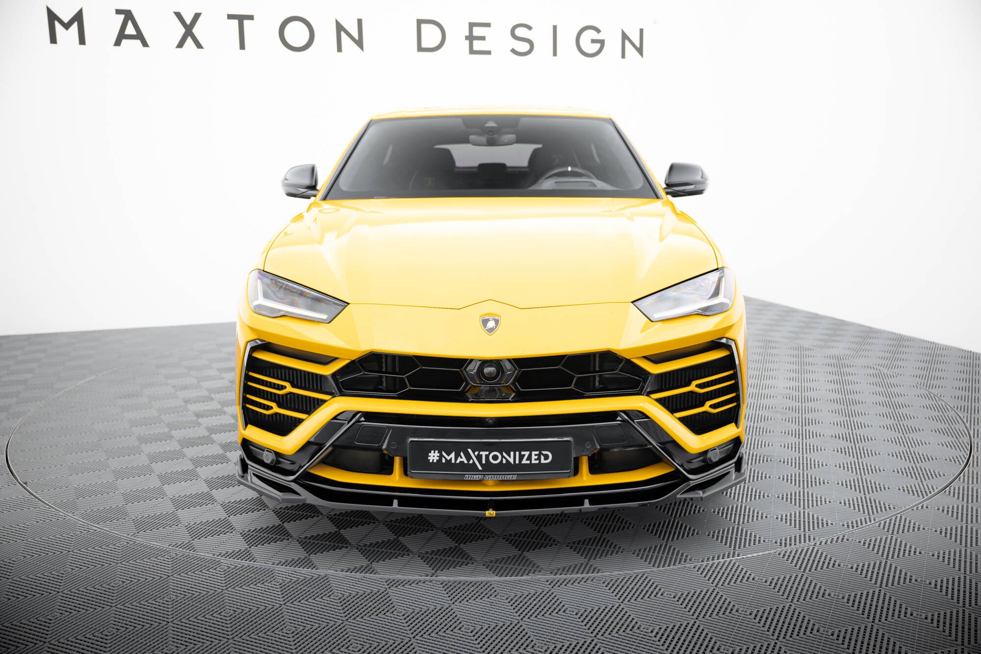 Frontleppe Lamborghini Urus MK1 V.3 på gul bil, sorte detaljer foran, fotostudio med grått mønstret gulv.