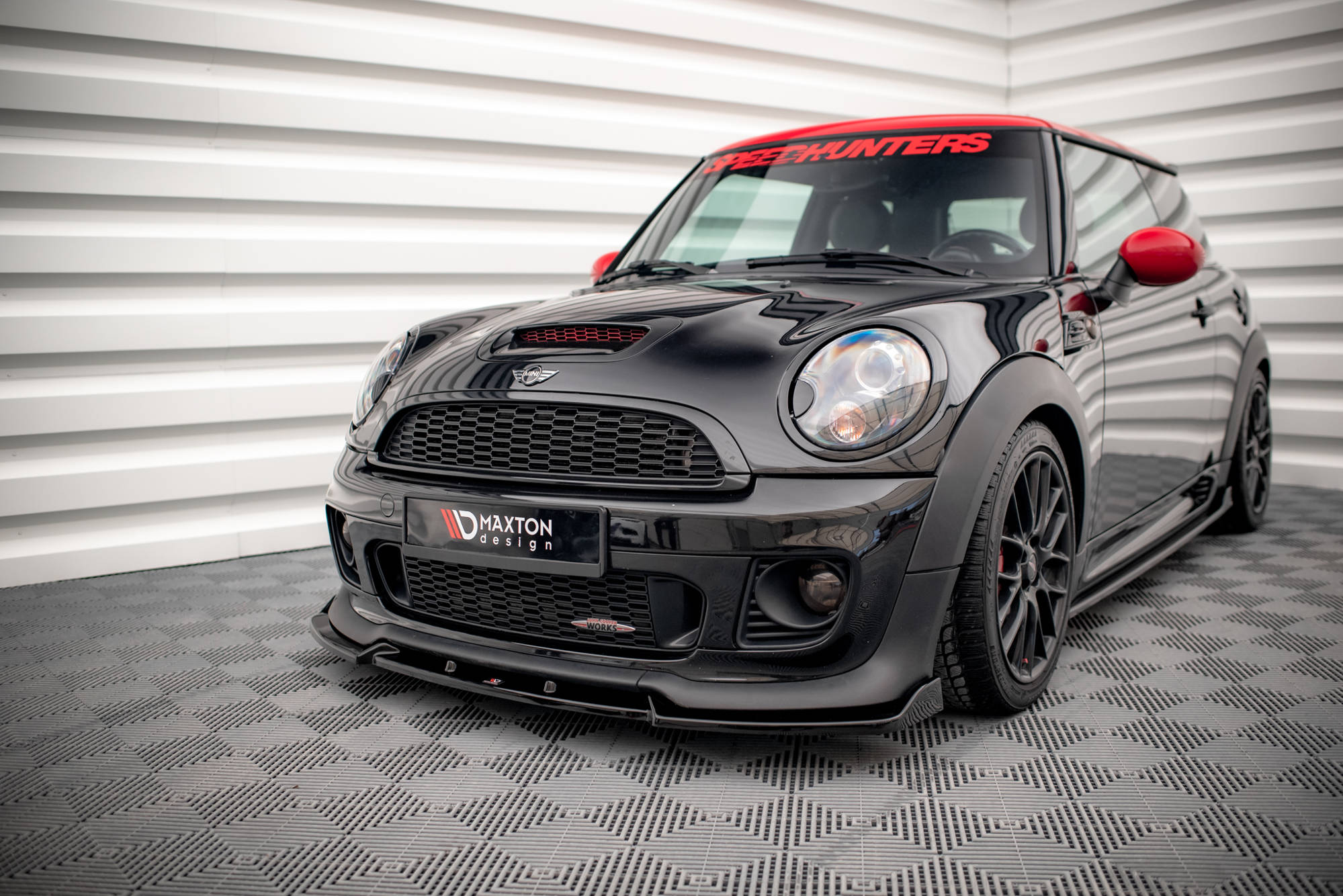 Frontspoiler Mini Cooper John Cooper Works R56 V.3 med røde detaljer og mattsvarte felger sett forfra.