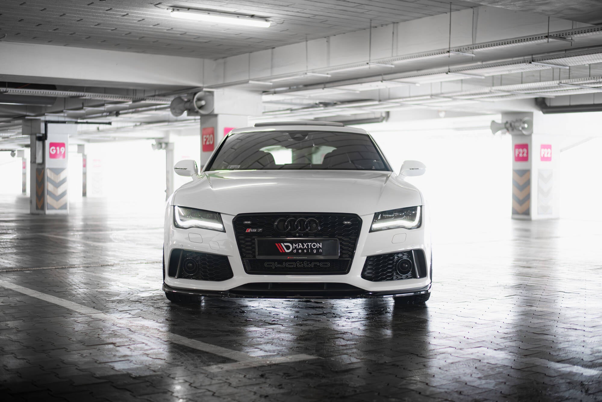 Spoiler på Audi RS7 C7 V.4 vist forfra med sorte detaljer og markante LED-lys i parkeringshus.