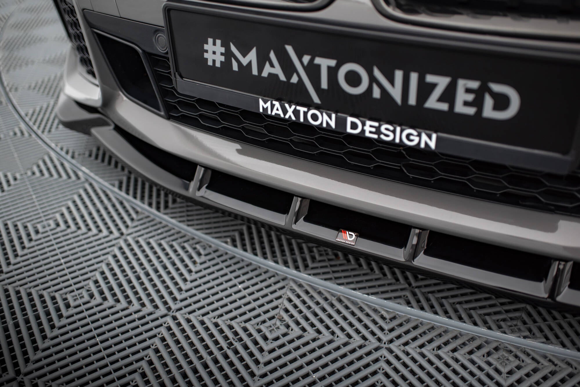 Spoiler til BMW 7 M-Pakke G11 G12 Facelift V.5 i blank svart plast med Maxton Design-logo.