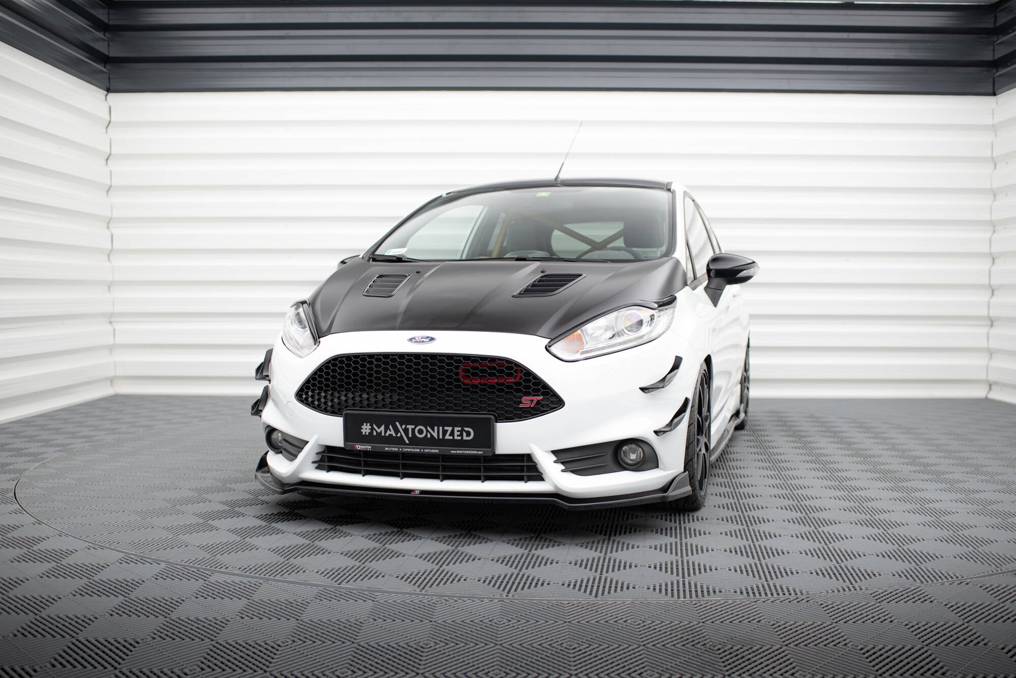 Frontspoiler Ford Fiesta St MK7 Facelift V.5 sett forfra med sort panser og rød detalj i grillen.