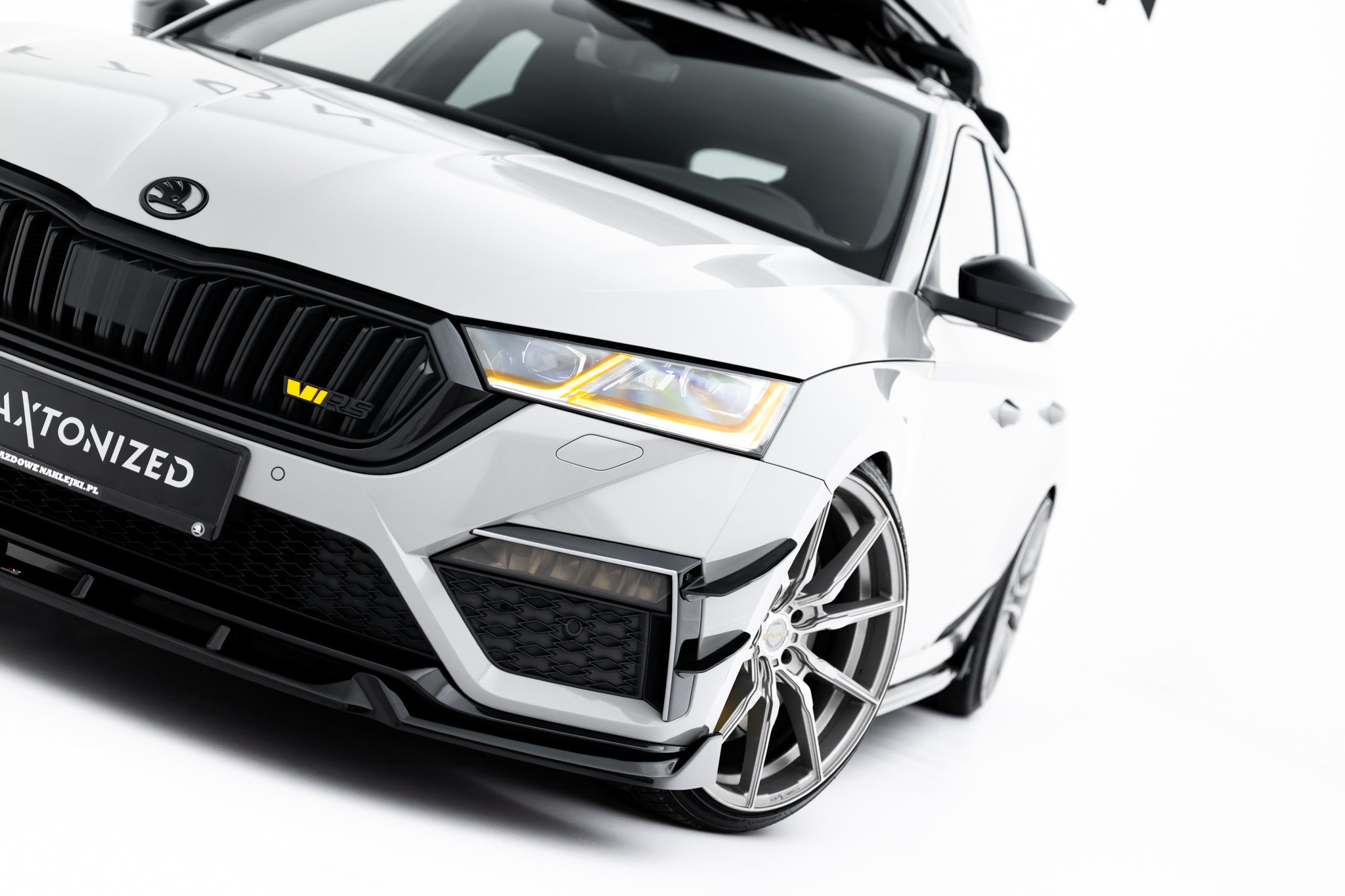 Spoiler til Skoda Octavia RS MK4 V.5, nærbilde av hvit bil med sorte detaljer og LED frontlykter.