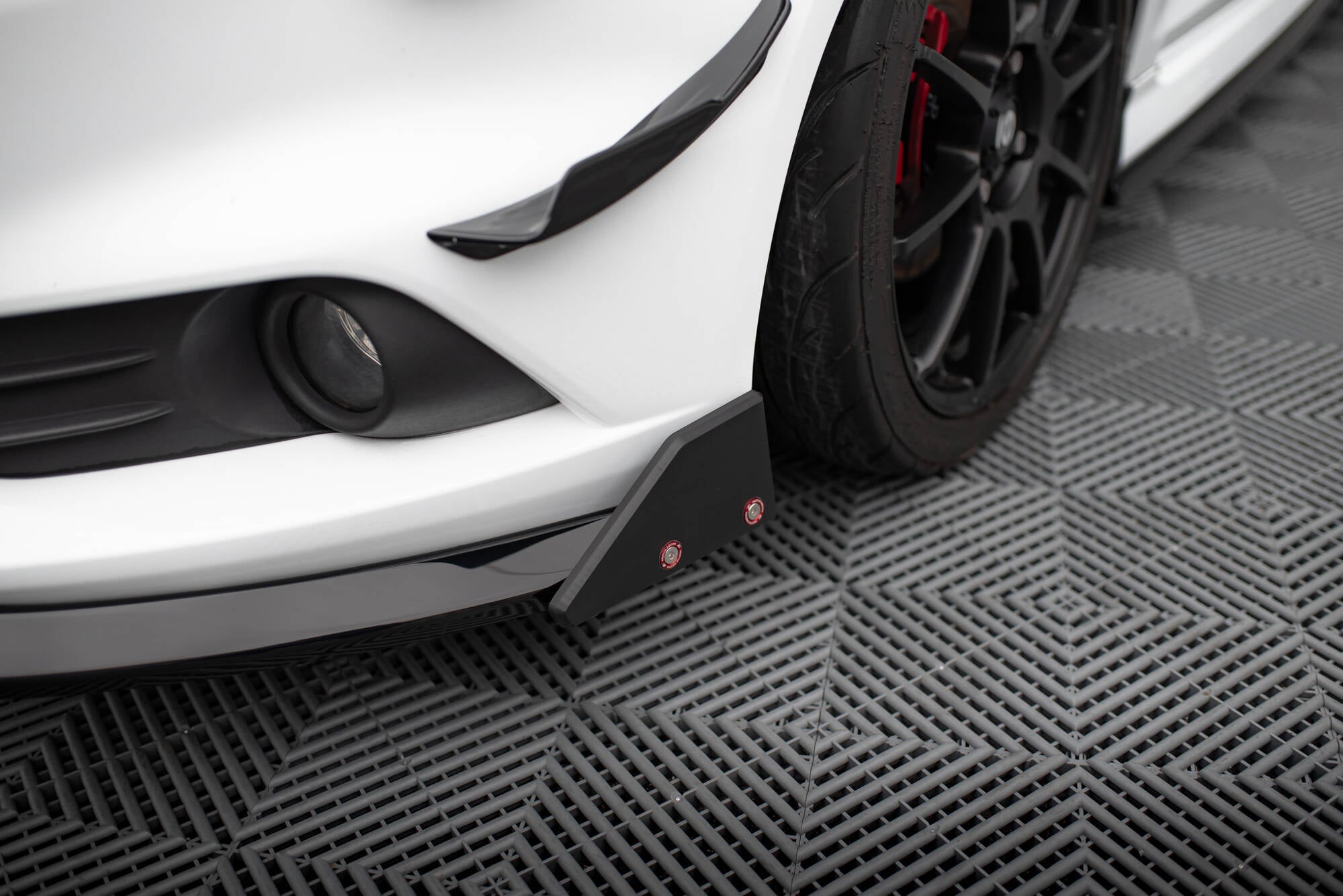 Front splitter på Ford Fiesta St MK7 Facelift med sorte detaljer, racinghjul og røde bremsekalipere.