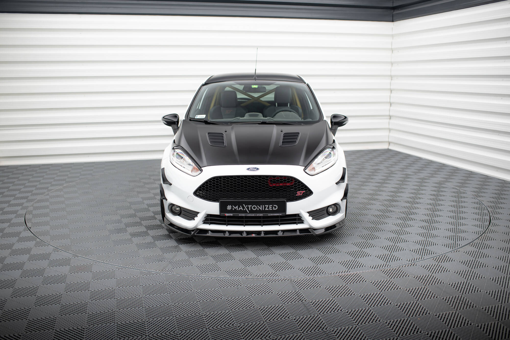 Frontleppe på Ford Fiesta St MK7 Facelift V.6 sett forfra med sort panser og rød grilldetalj.