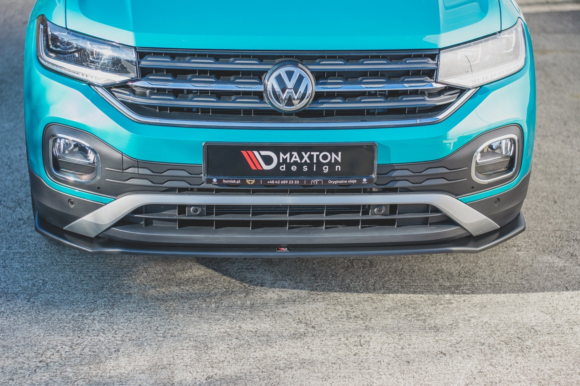 Frontspoiler til VW T-Cross montert under støtfangeren på turkis bil med krom og mattsvarte detaljer.