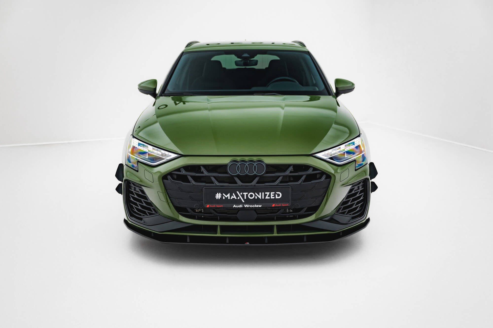 Frontleppe til Audi S3 Sportback 8Y Facelift, olivengrønn bil med sort grill og sporty detaljer, sett forfra.